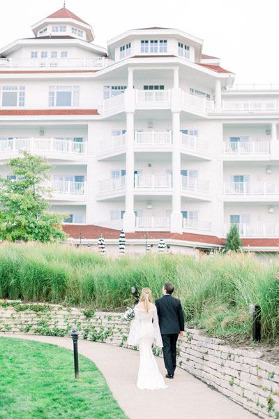 Bride and groom walk toward Inn at Bay Harbor hotel