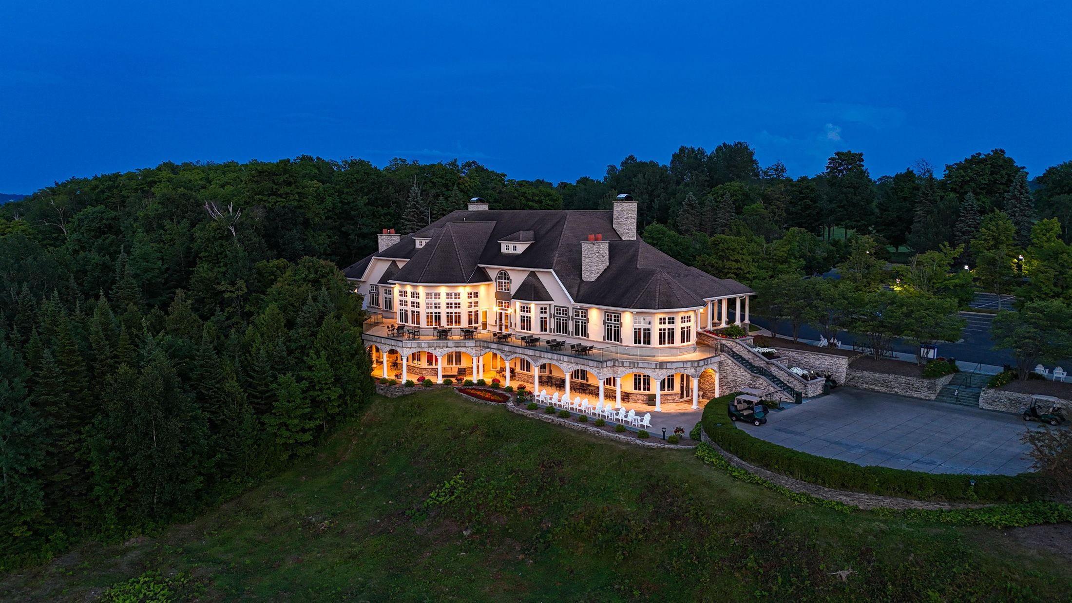 Bay Harbor Golf Club clubhouse with lights on under evening sky