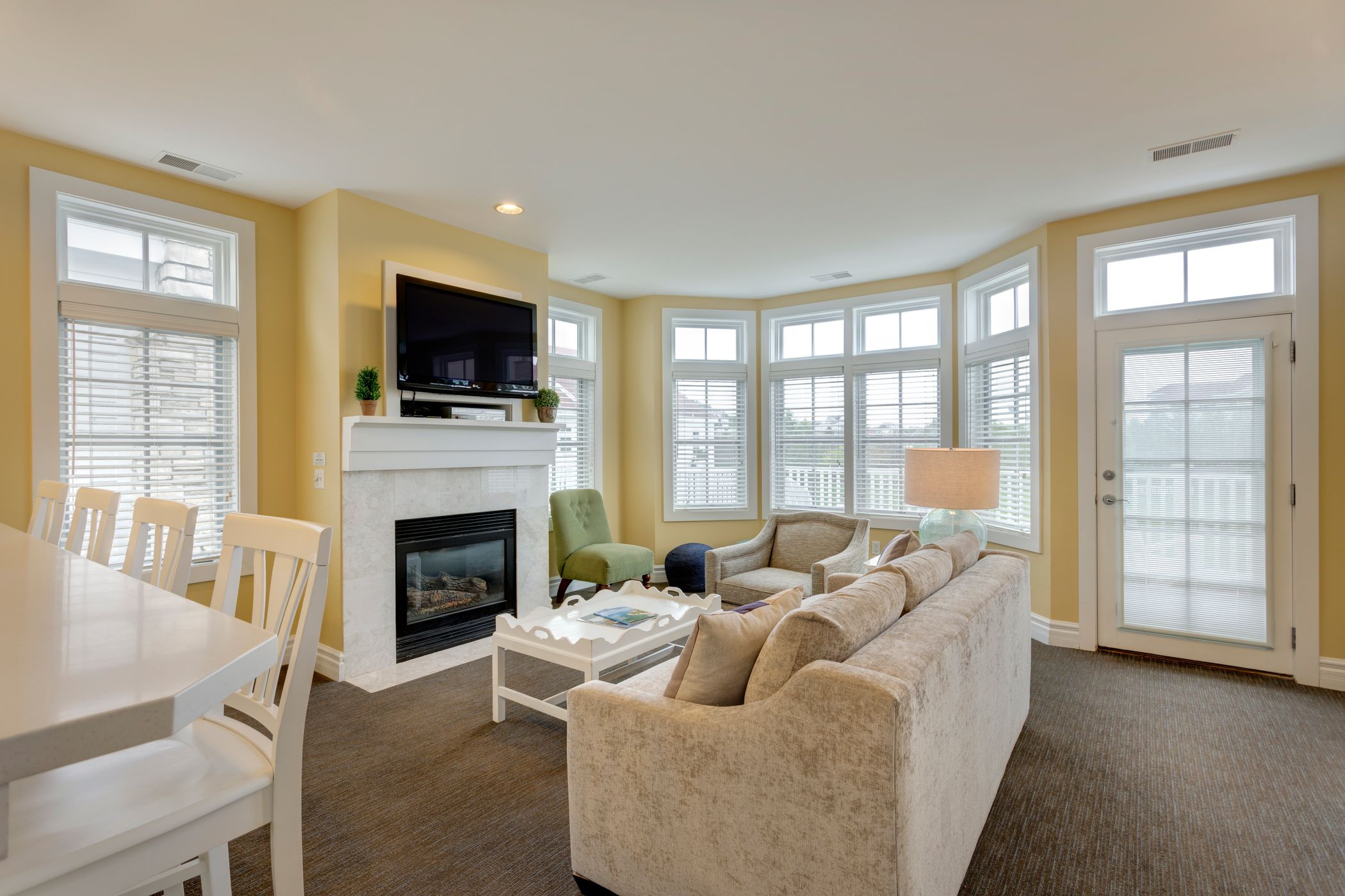 Living area with fireplace near large windows, Lakeside Cottages at Bay Harbor