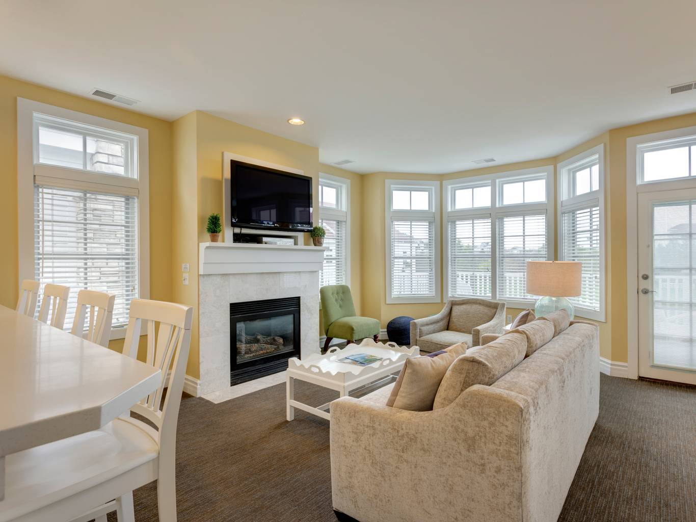 Living area with fireplace near large windows, Lakeside Cottages at Bay Harbor