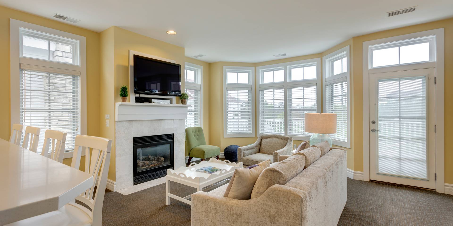 Living area with fireplace near large windows, Lakeside Cottages at Bay Harbor