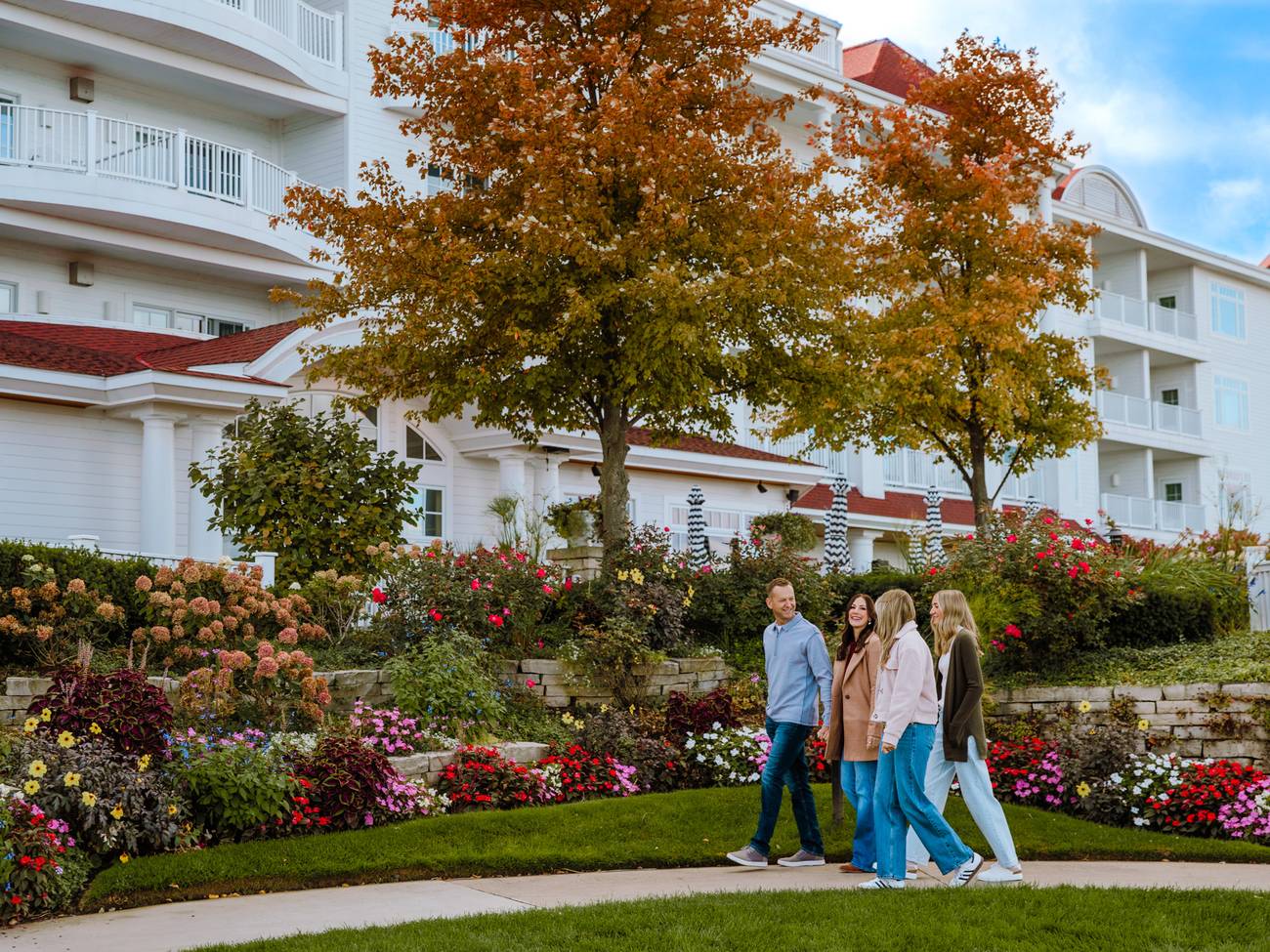 Family of four walks near colorful autumn gardens, Inn at Bay Harbor