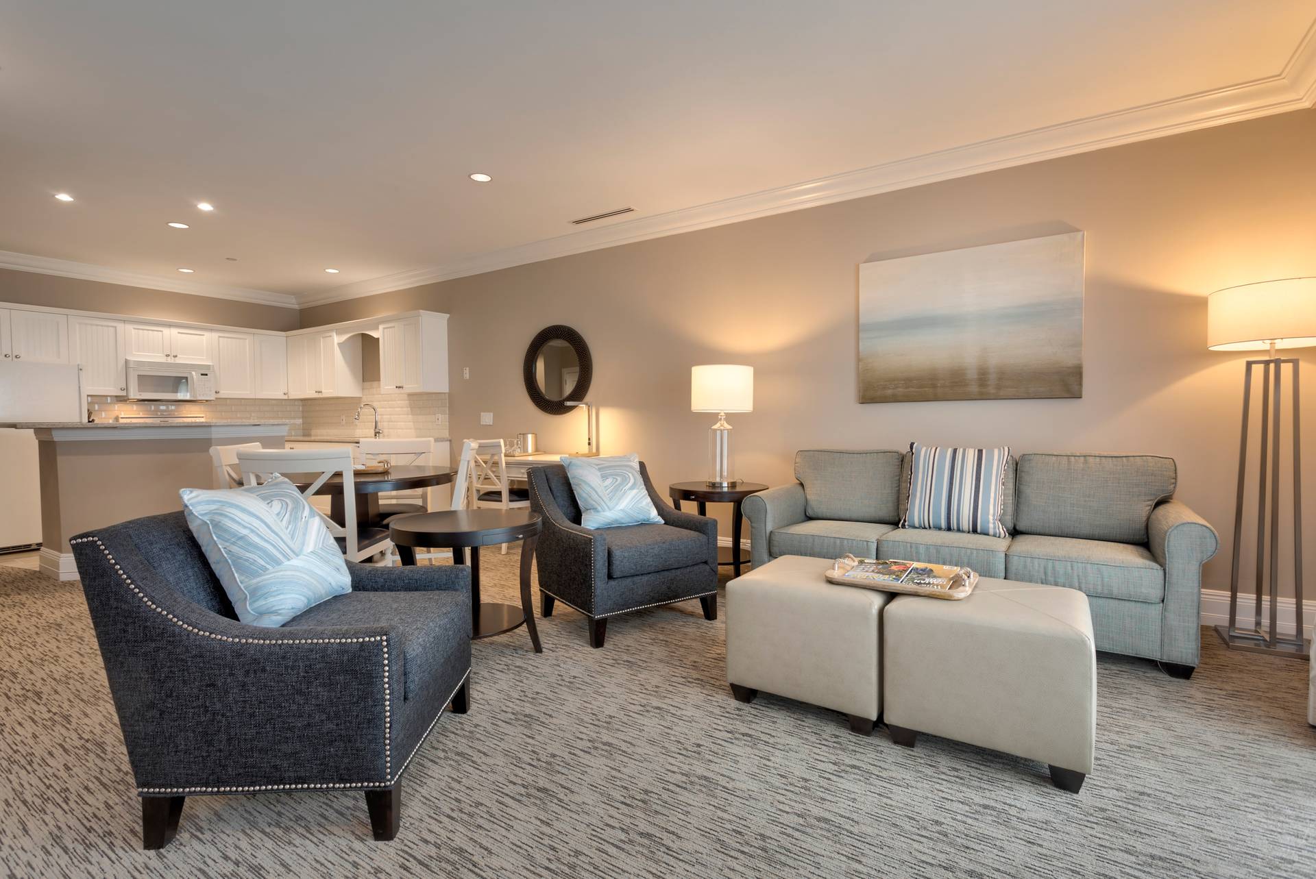 Dark chairs and neutral couches near dining area and kitchen, Specialty Suite of Inn at Bay Harbor