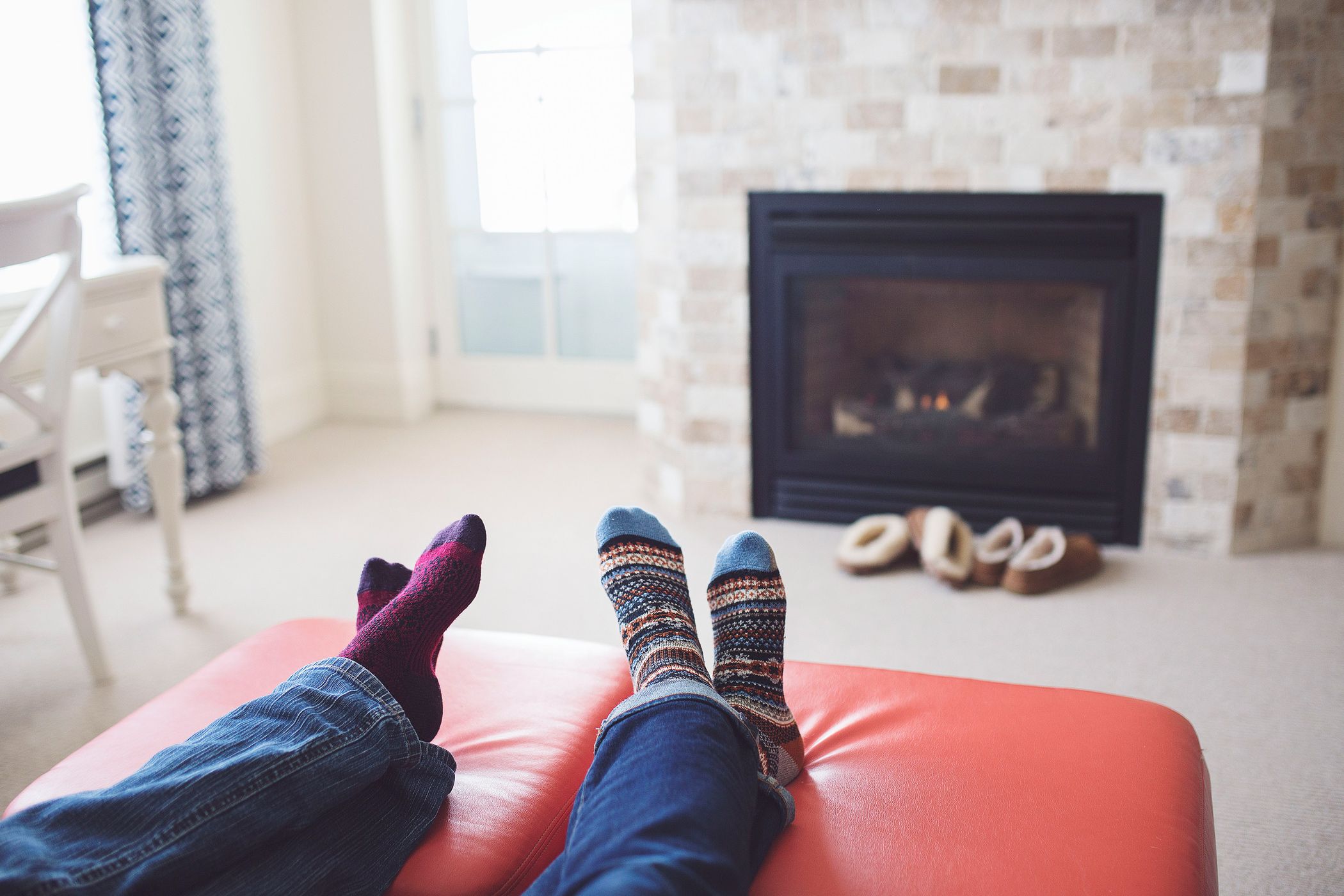 Couple's cozy feet by in-room fireplace