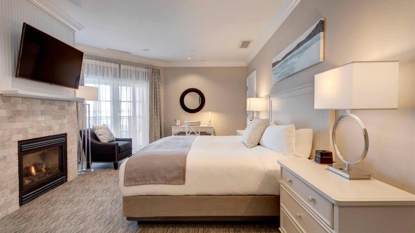 Side view of king bed, stone fireplace in front of decor in Tower King hotel room