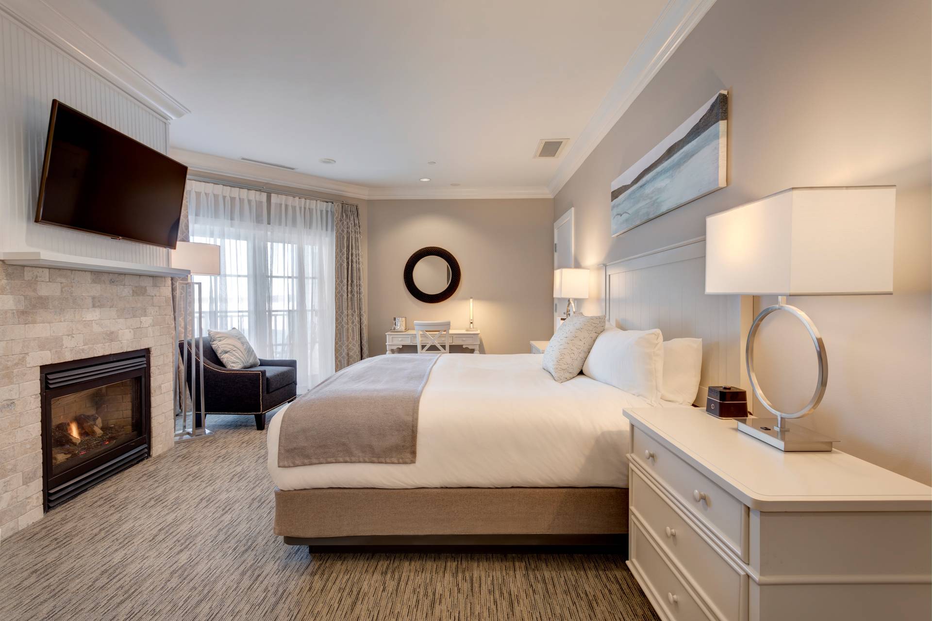 Side view of king bed, stone fireplace in front of decor in Tower King hotel room