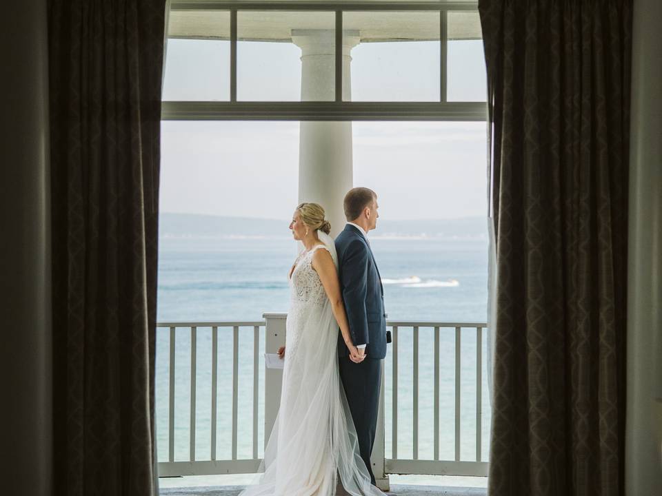 Inn at Bay Harbor wedding couple stand back to back, tower balcony overlooking Lake Michigan