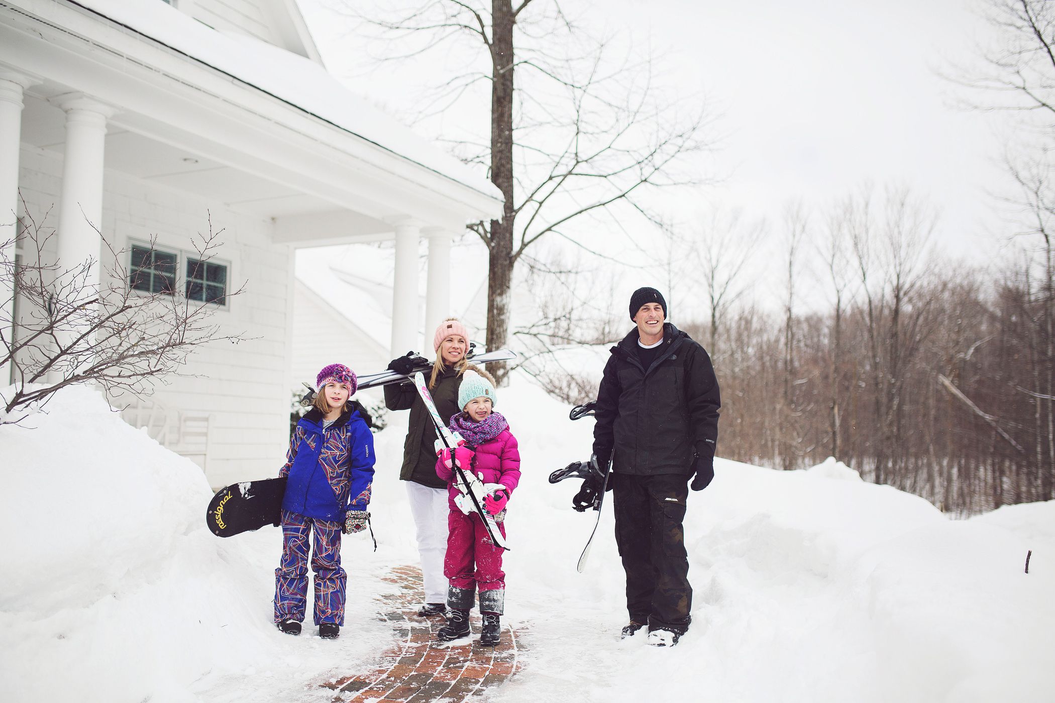 A family poses out front of a Cottage before heading to ski