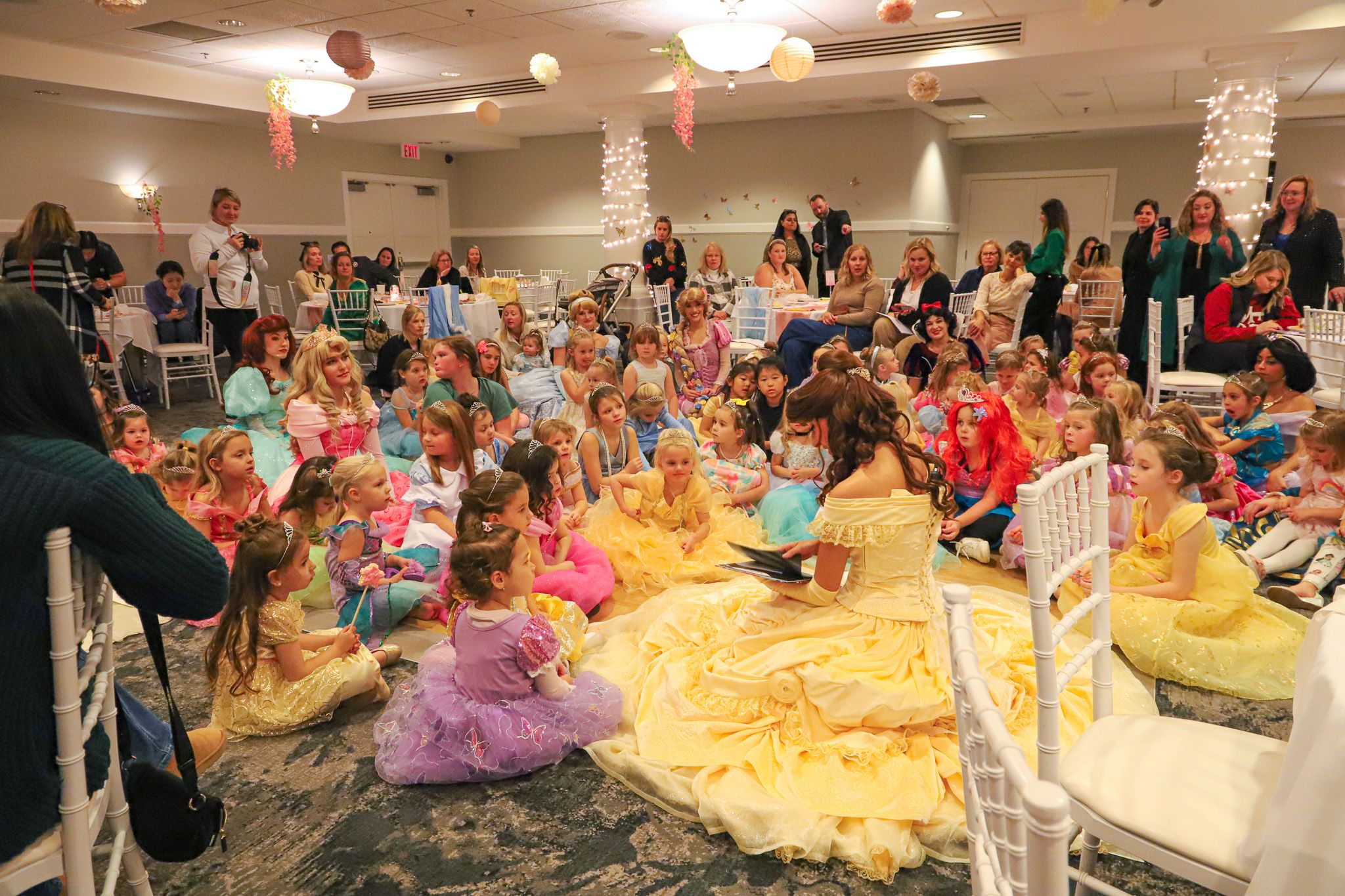 Belle character reads to young Princess Gala guests