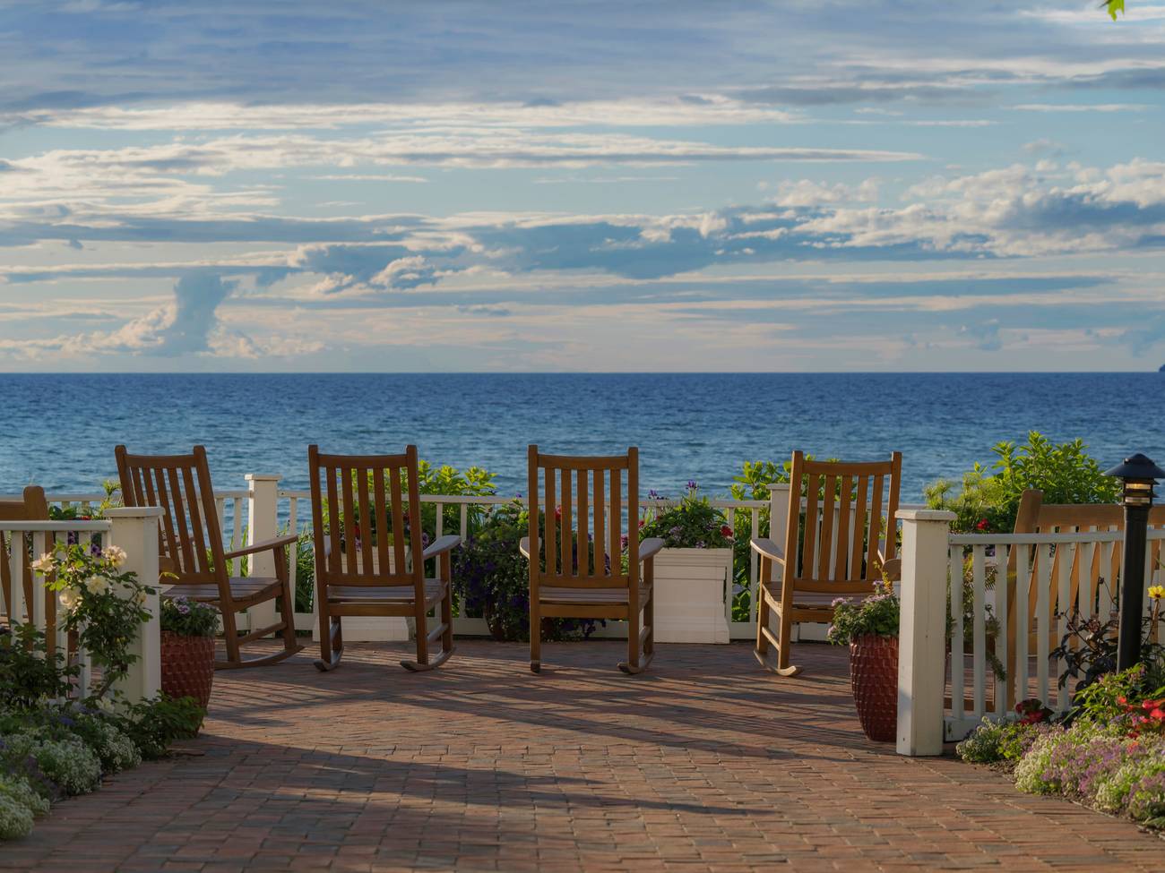Wooden rocking chairs on garden patio overlooking sunset on Lake Michigan, Inn at Bay Harbor