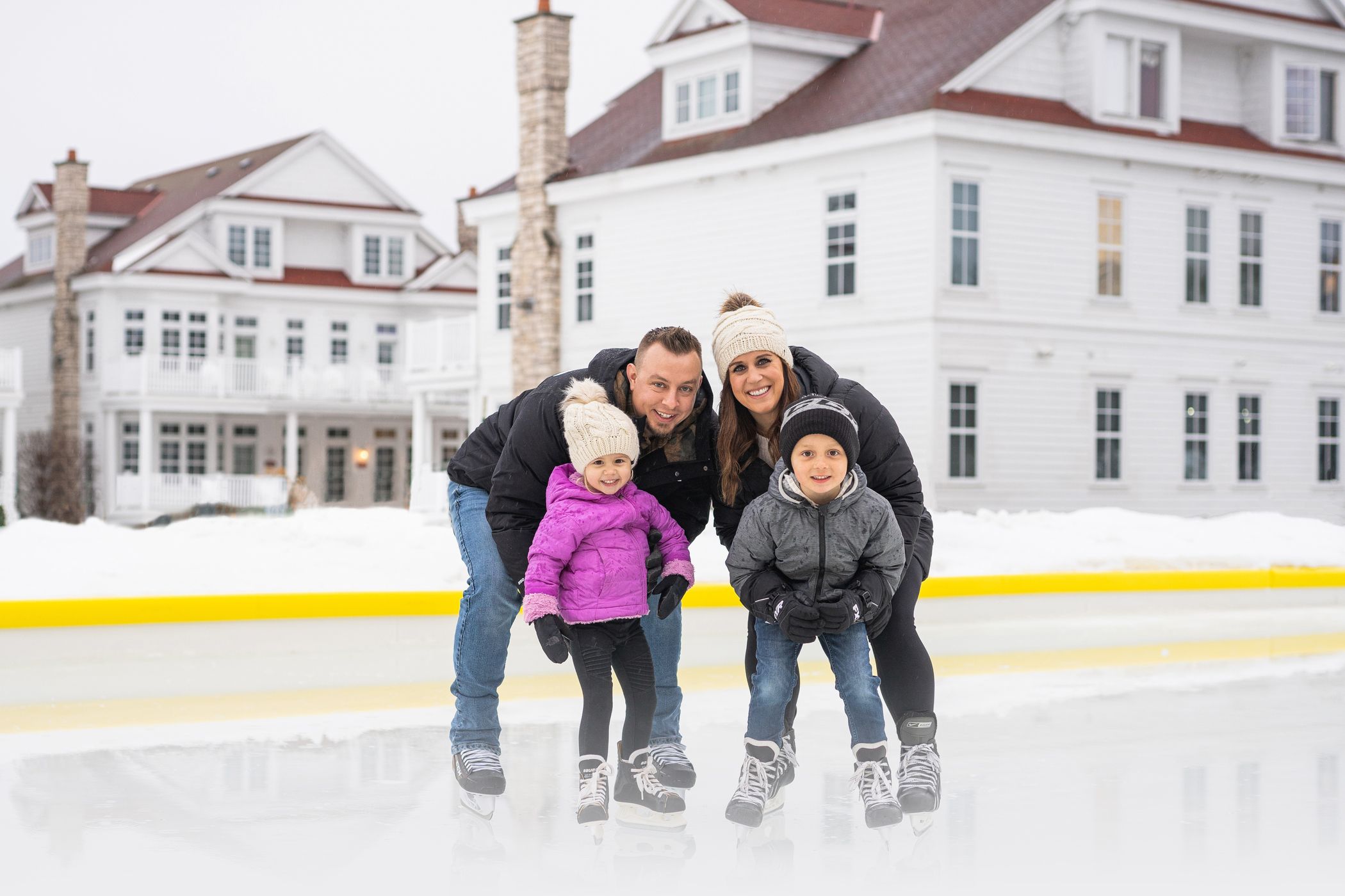 Family poses on skates at Inn at Bay Harbor outdoor ice rink