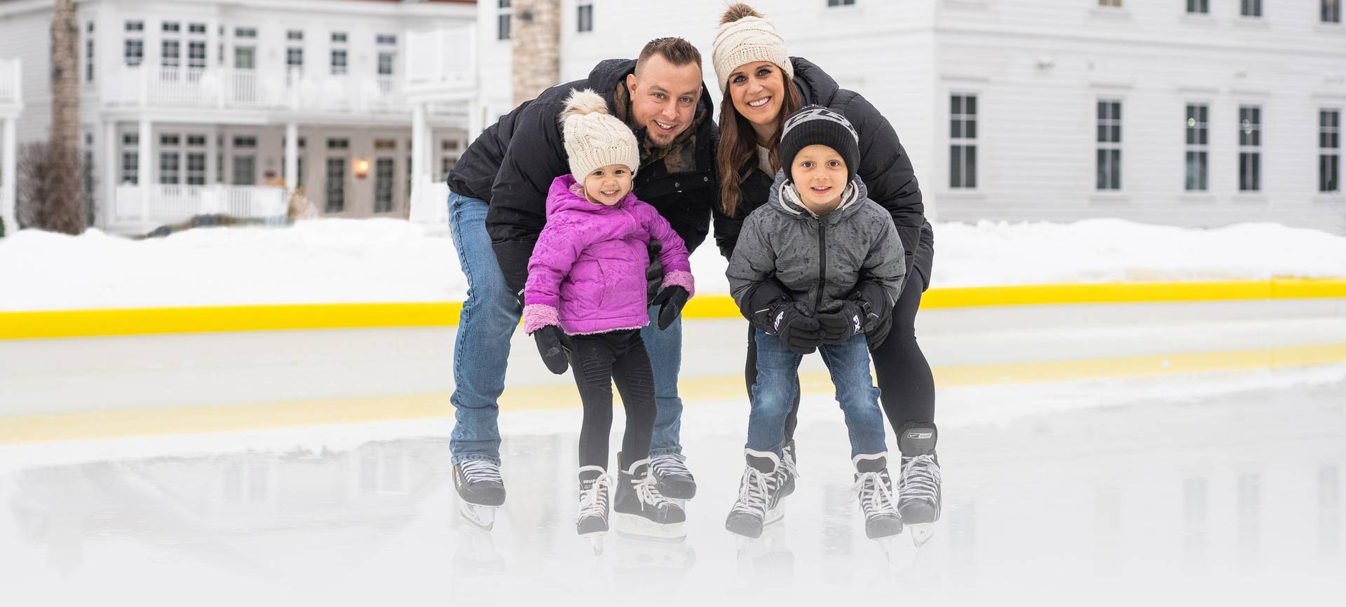 Family poses on skates at Inn at Bay Harbor outdoor ice rink