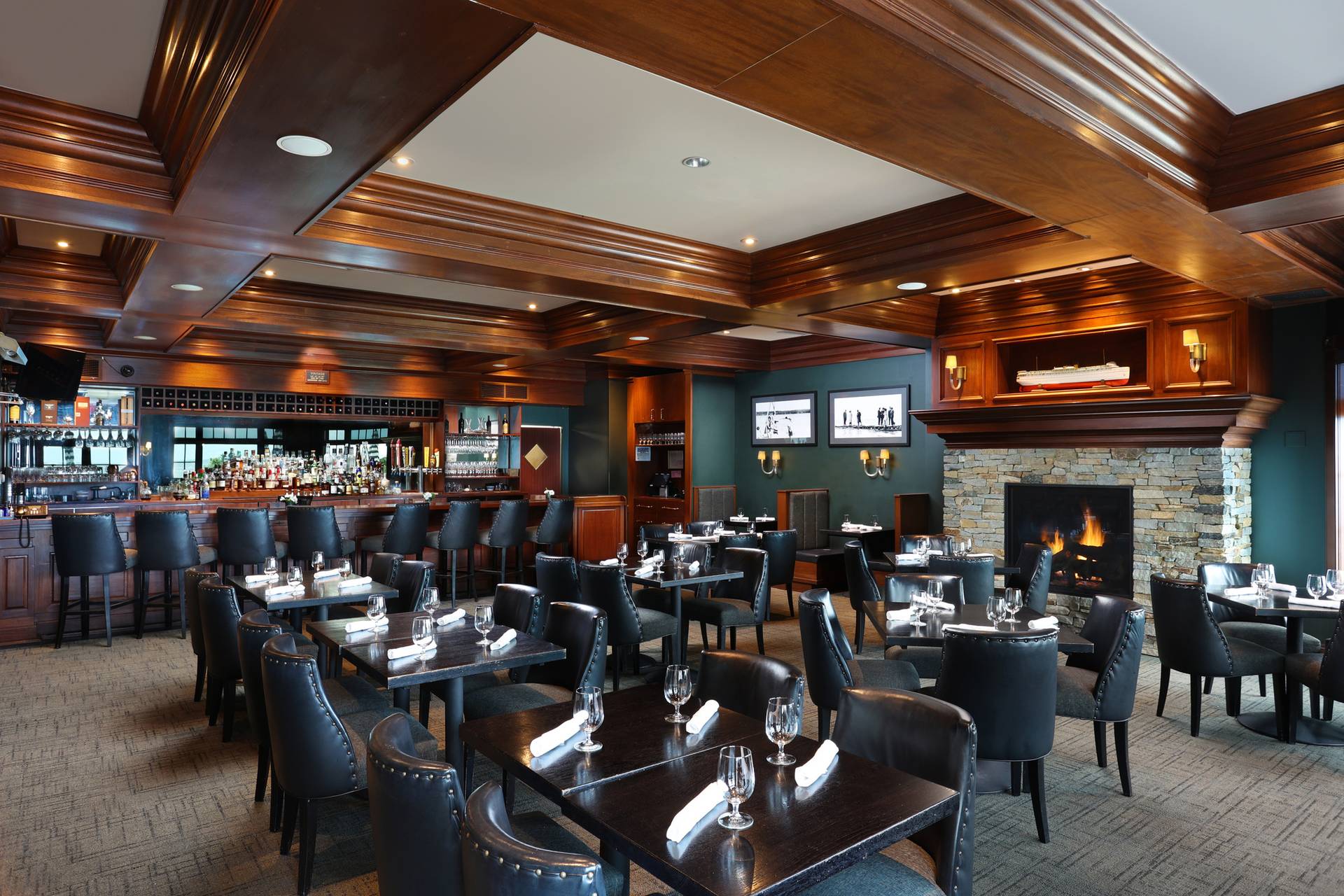 Overall view of Vintage restaurant interior, with fireplace, wooden ceilings, black tables and chairs