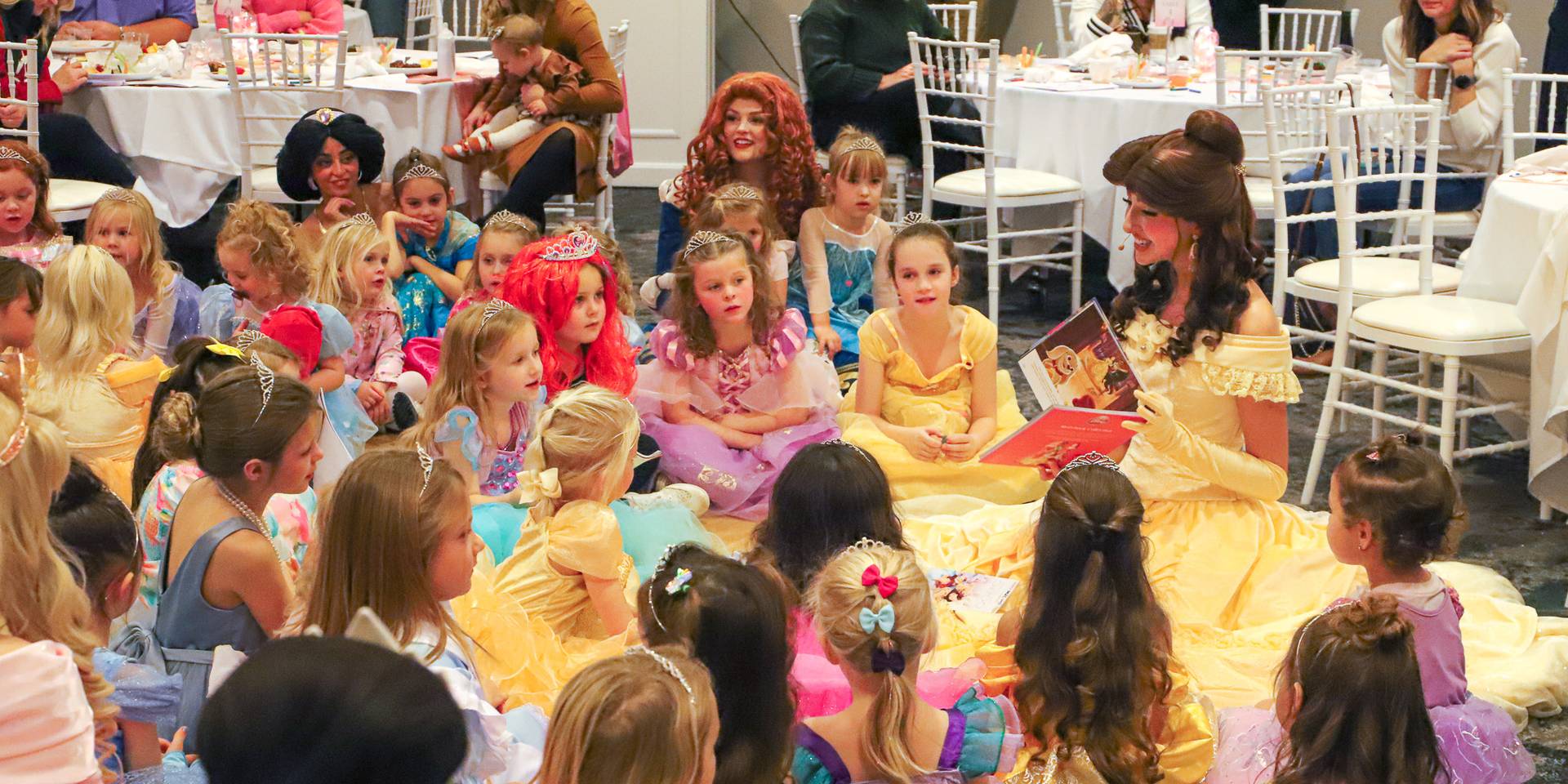 Belle character reads story to Princess Gala young guests