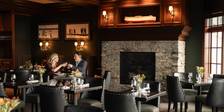Smiling couple toasts wine in romantic, dim dining room, Vintage Chophouse at Inn at Bay Harbor