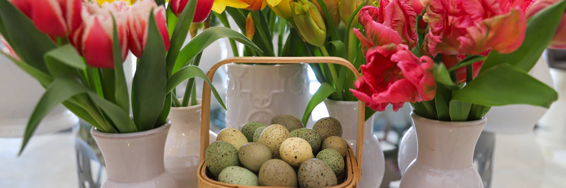 Mini Easter egg basket surrounded by colorful spring flowers