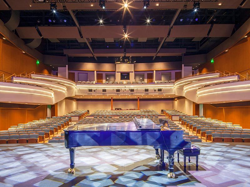 Blue piano on lit stage looking out onto theatre, Great Lakes Center for the Arts