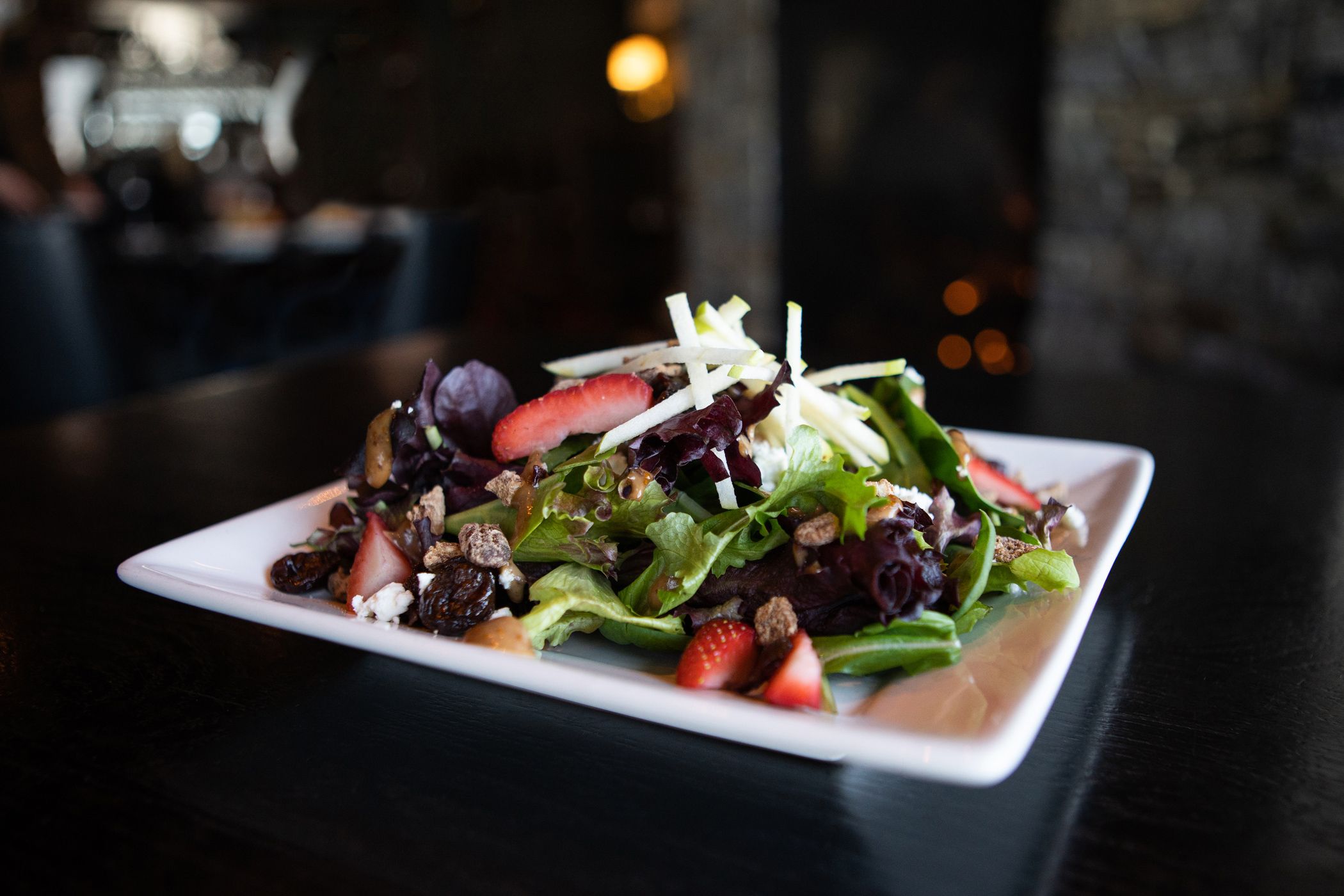 Detail of Vintage Salad, with vibrant greens, strawberries, apple, and pecans