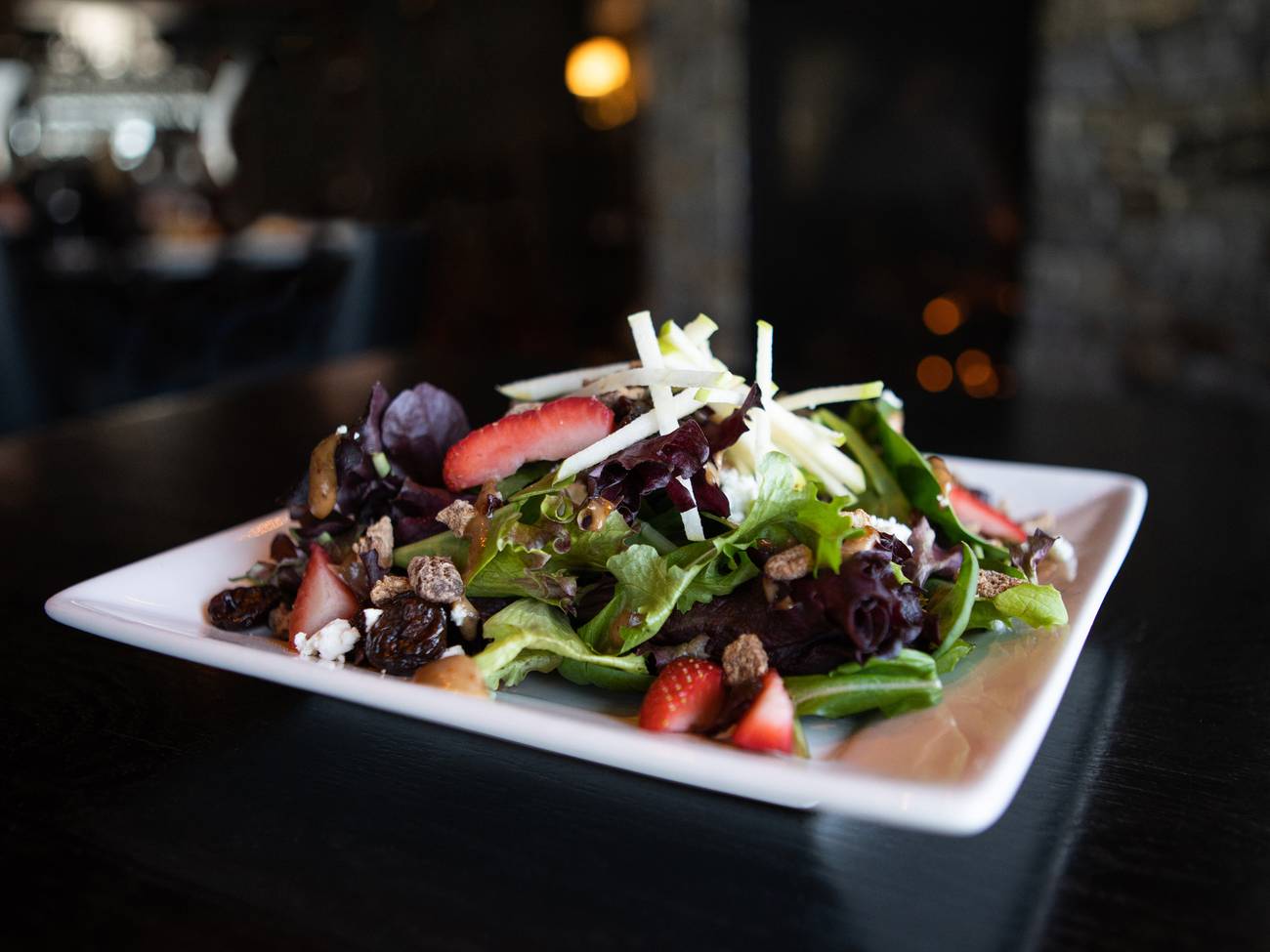 Detail of Vintage Salad, with vibrant greens, strawberries, apple, and pecans
