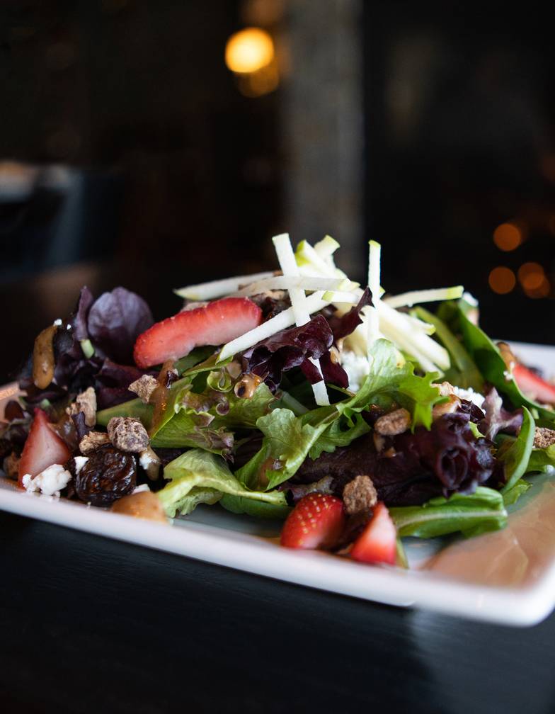 Detail of Vintage Salad, with vibrant greens, strawberries, apple, and pecans