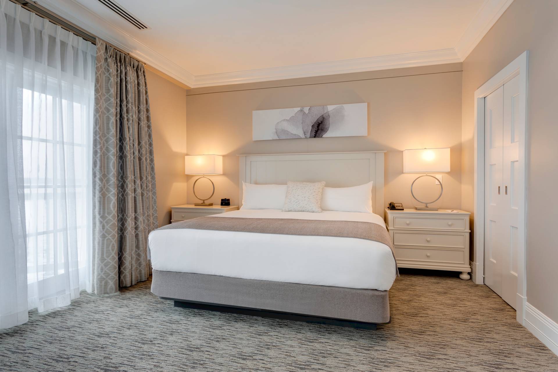 Specialty suite master bedroom detail with tableside lights on near large window