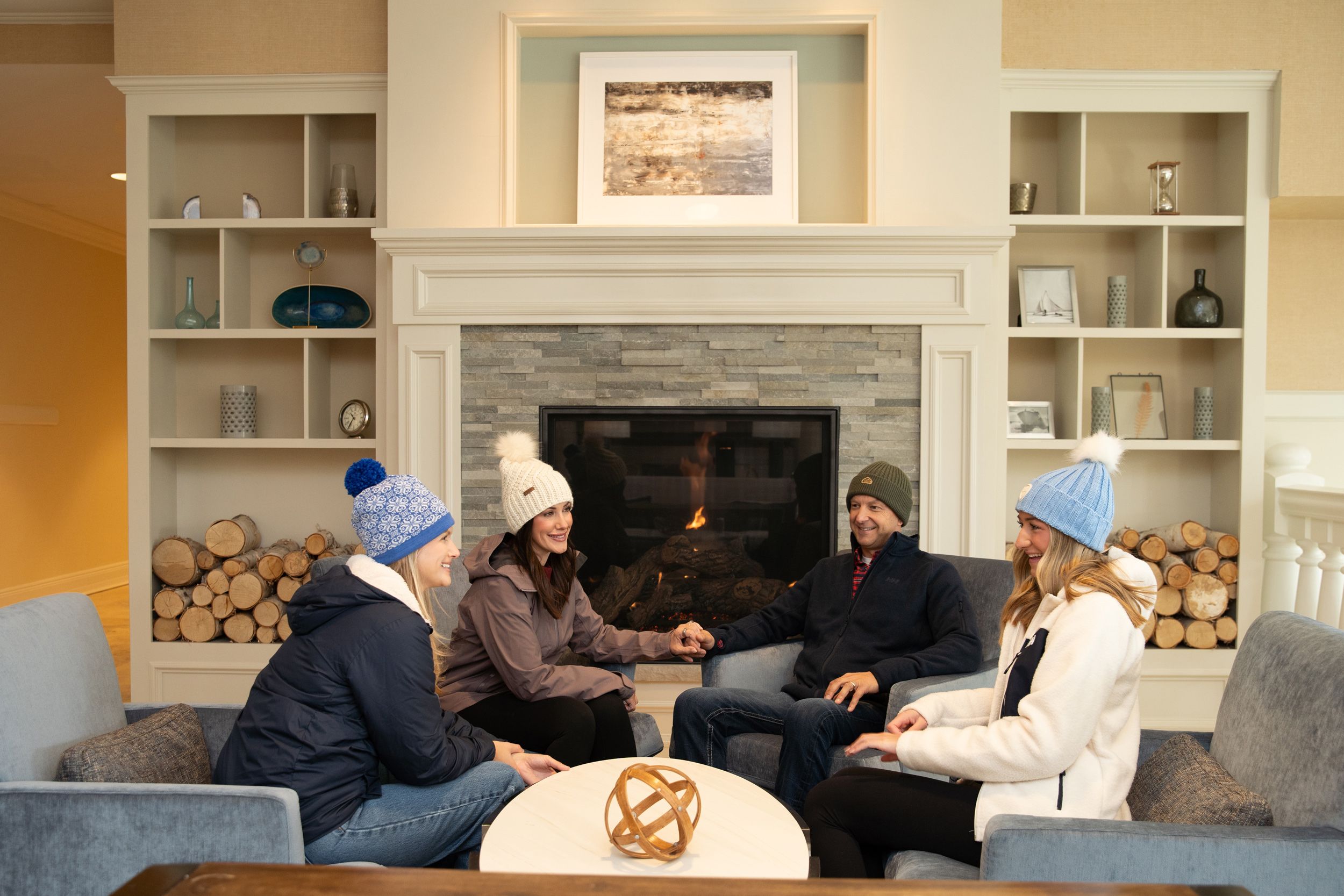 winter family laughs in front of fireplace, Inn at Bay Harbor lobby