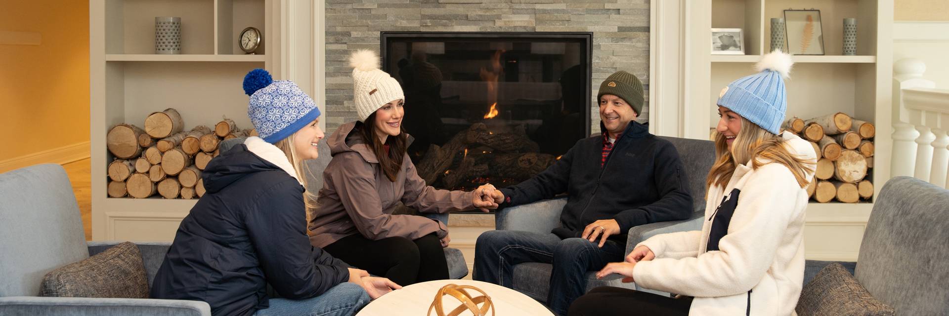 winter family laughs in front of fireplace, Inn at Bay Harbor lobby