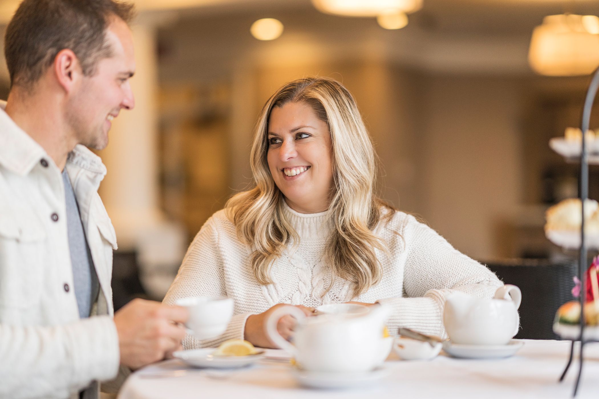 Couple smiles at each other while enjoying Afternoon Tea service