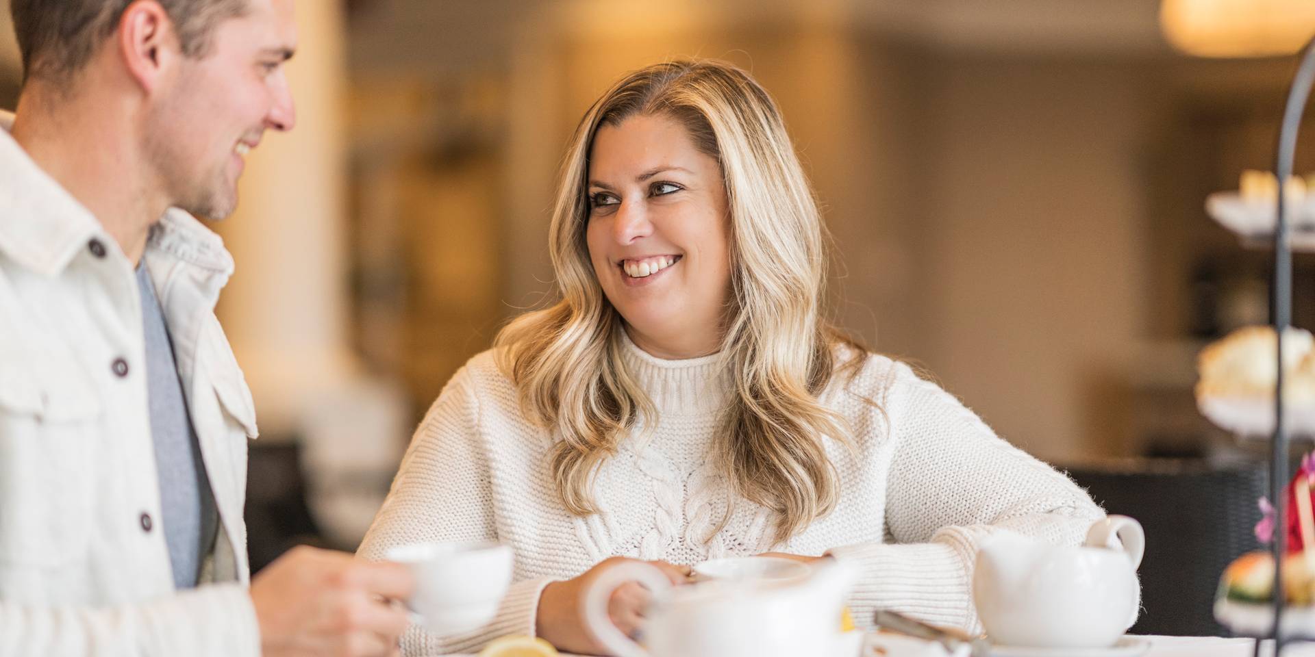 Couple smiles at each other while enjoying Afternoon Tea service