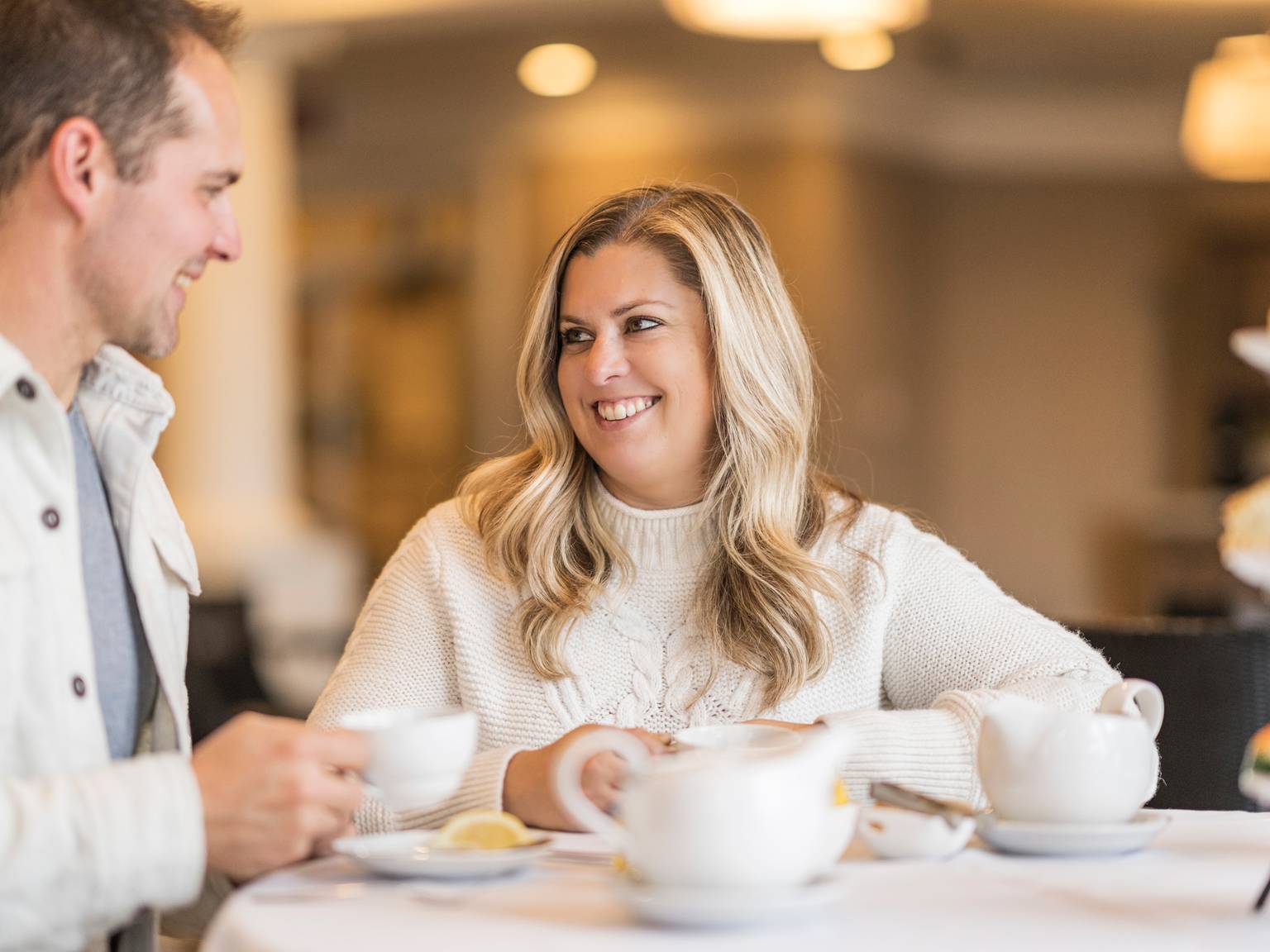 Couple smiles at each other while enjoying Afternoon Tea service