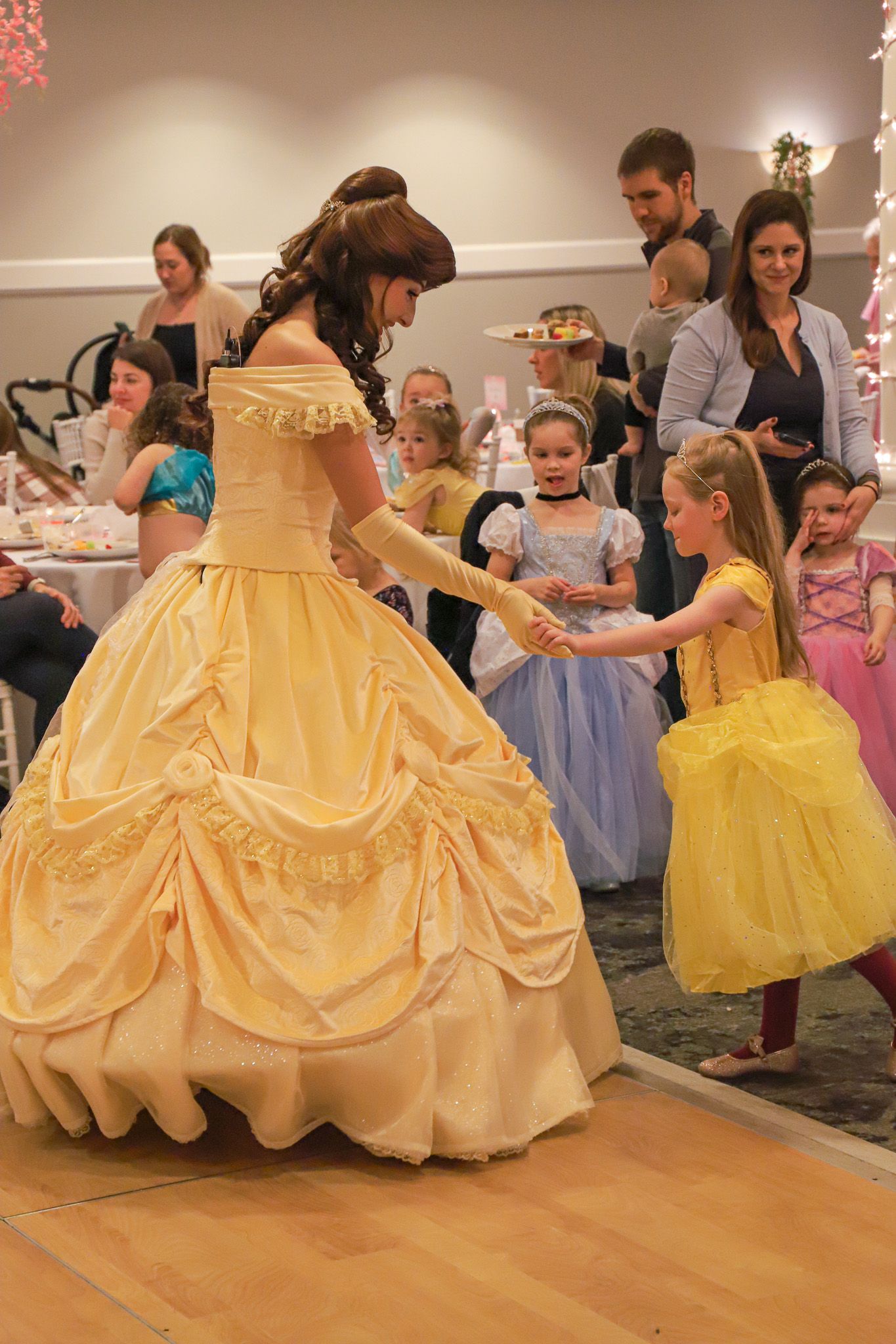 Princess Belle character smiles with young Princess Gala guest