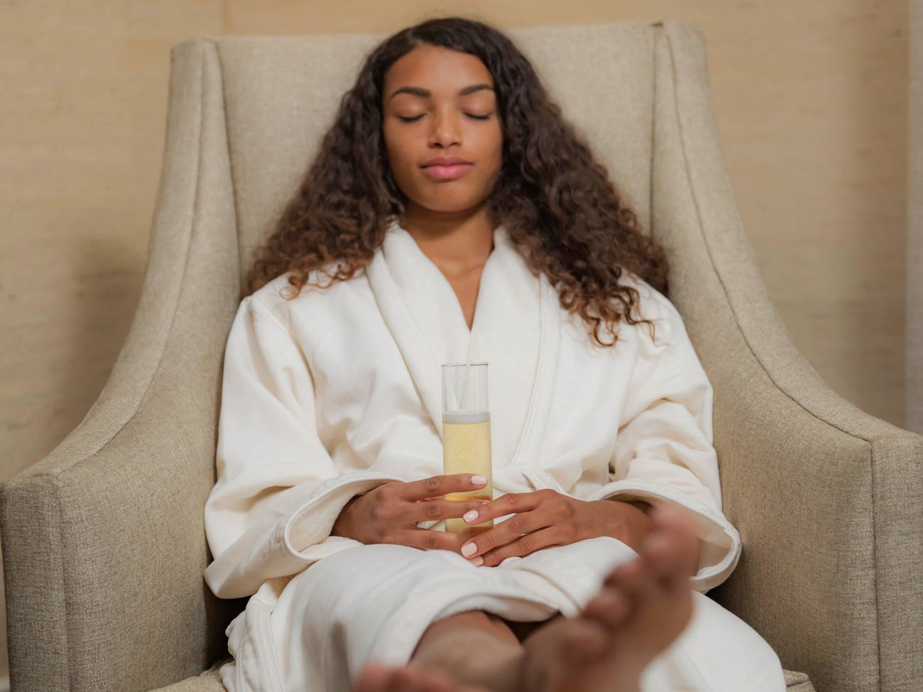 Woman relaxing in robe with champagne