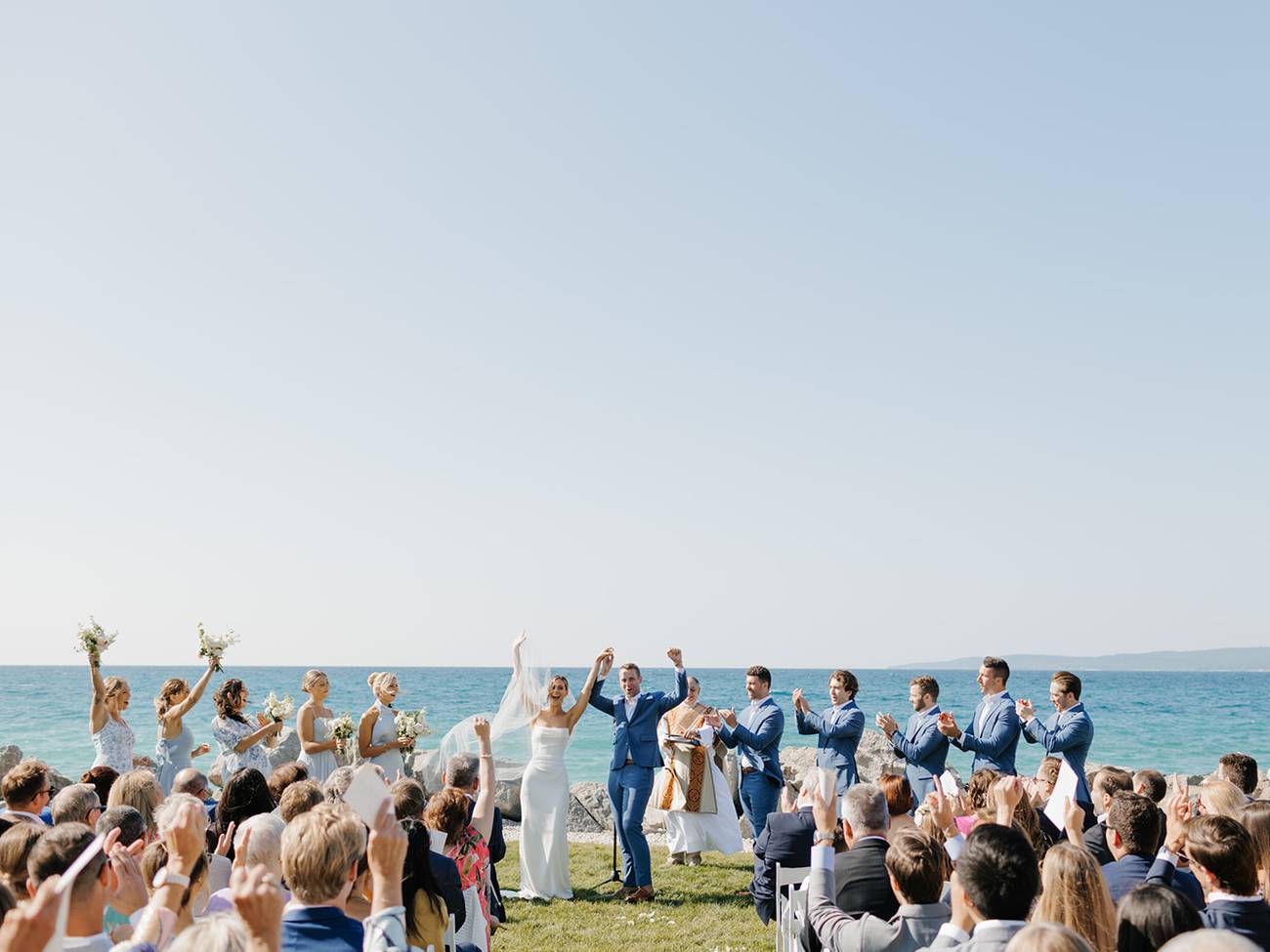 Newlyweds and bridal party celebrate at lakefront ceremony