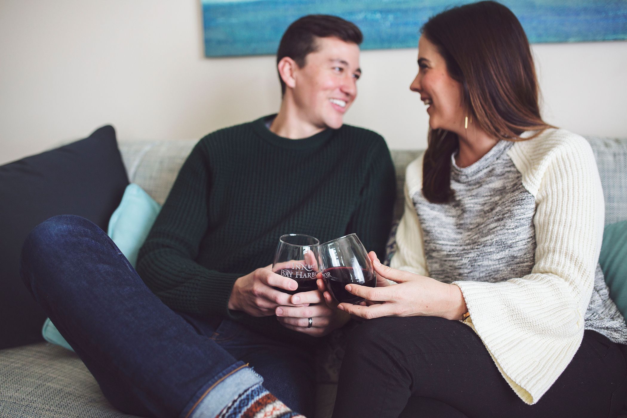 Young couple in winter apparel smiles with red wine, Inn at Bay Harbor