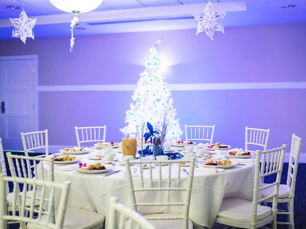 Breakfast and tea cups with blue sparkling table decor and white lit tree