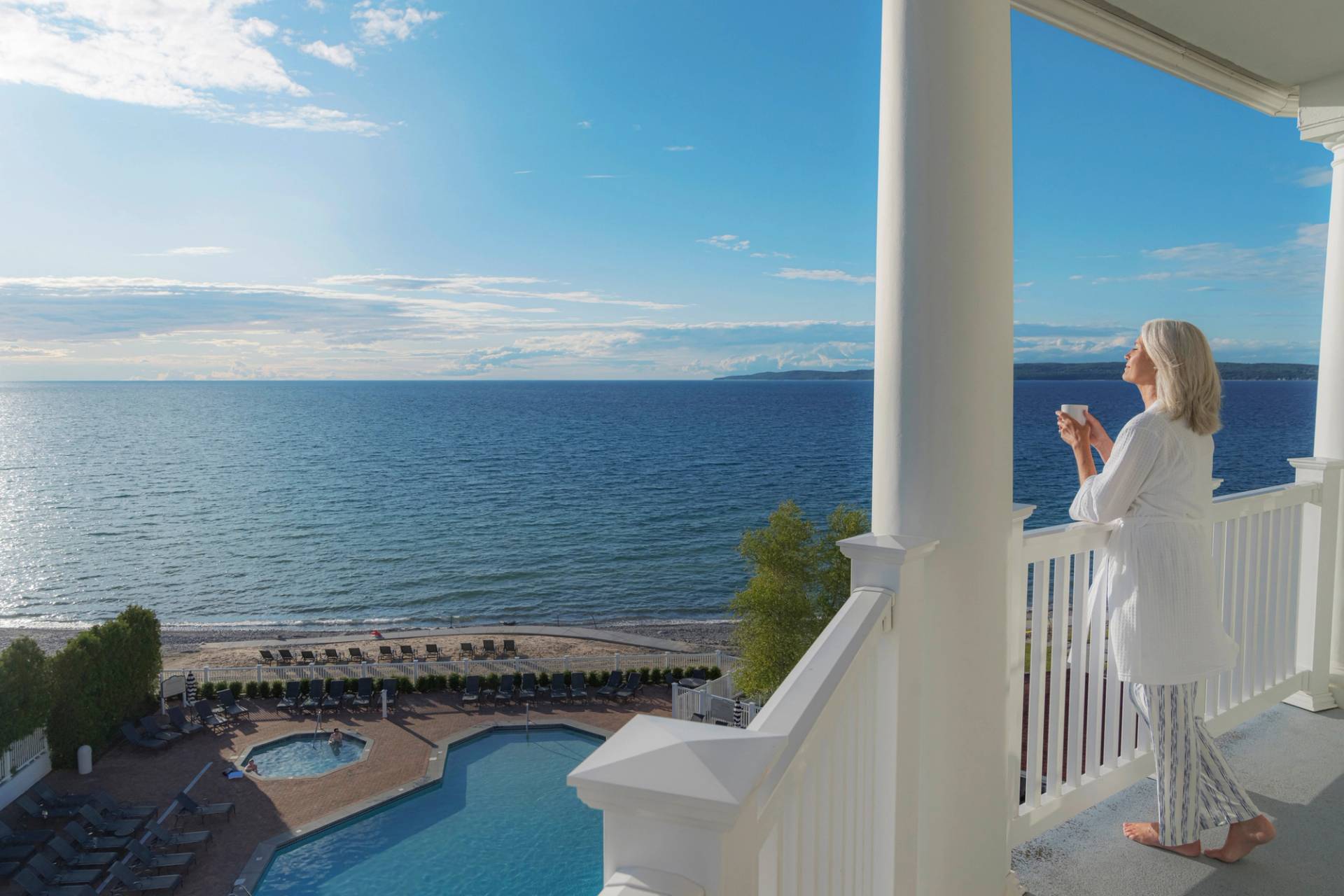 Woman with coffee on lakefront balcony