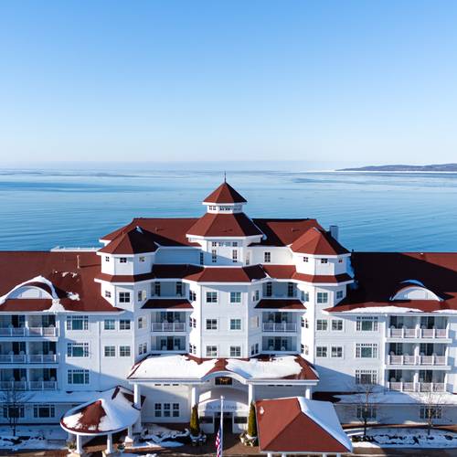 Winter Inn at Bay Harbor snowy aerial drone view in front of calm blue Lake Michigan