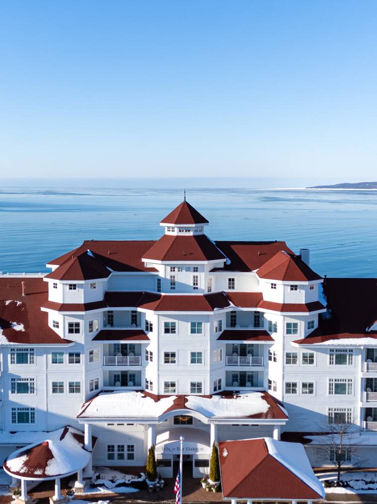 Winter Inn at Bay Harbor snowy aerial drone view in front of calm blue Lake Michigan