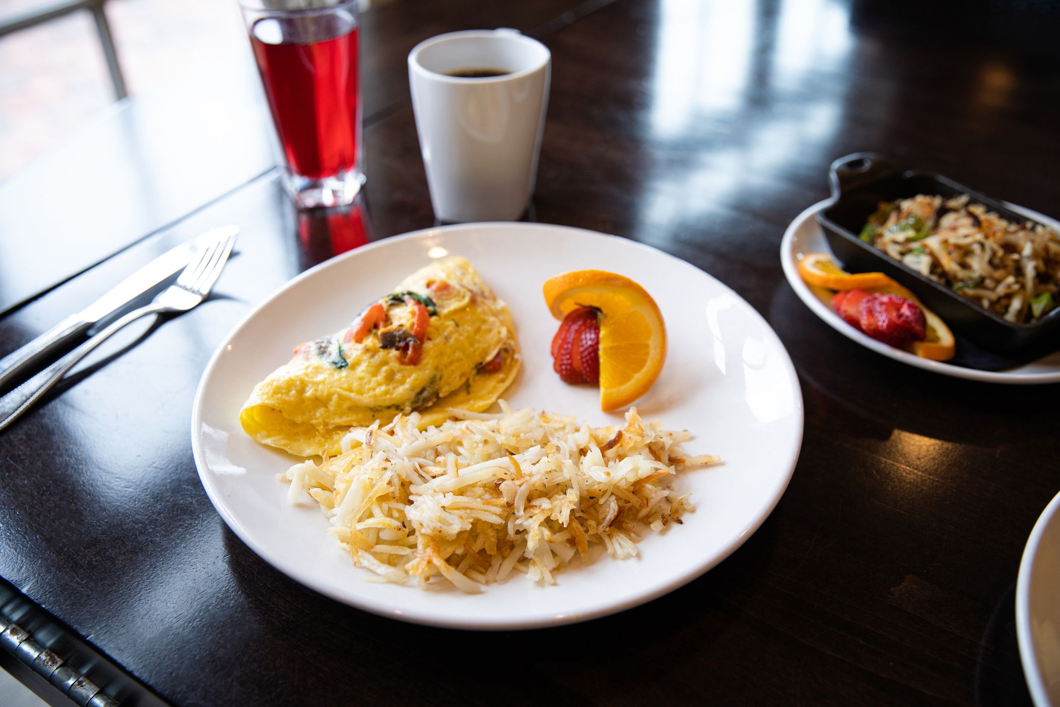 breakfast plate with omelet, hash browns, and more