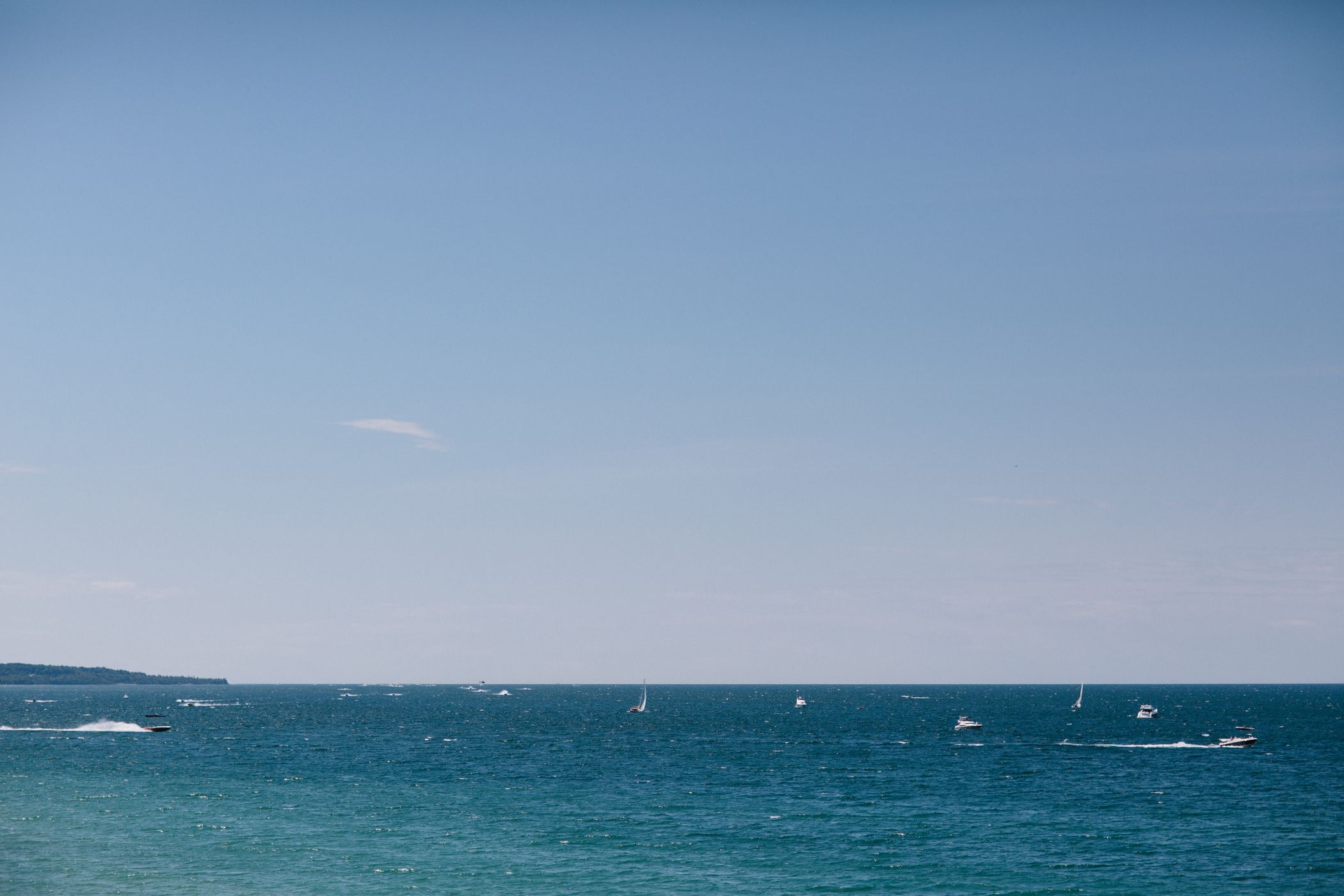 Boats sailing on blue waters of Little Traverse Bay, summer