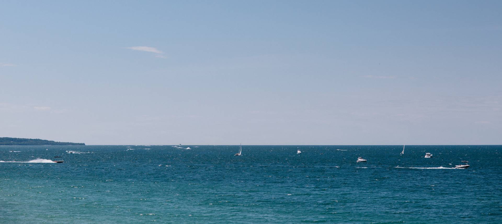 Boats sailing on blue waters of Little Traverse Bay, summer