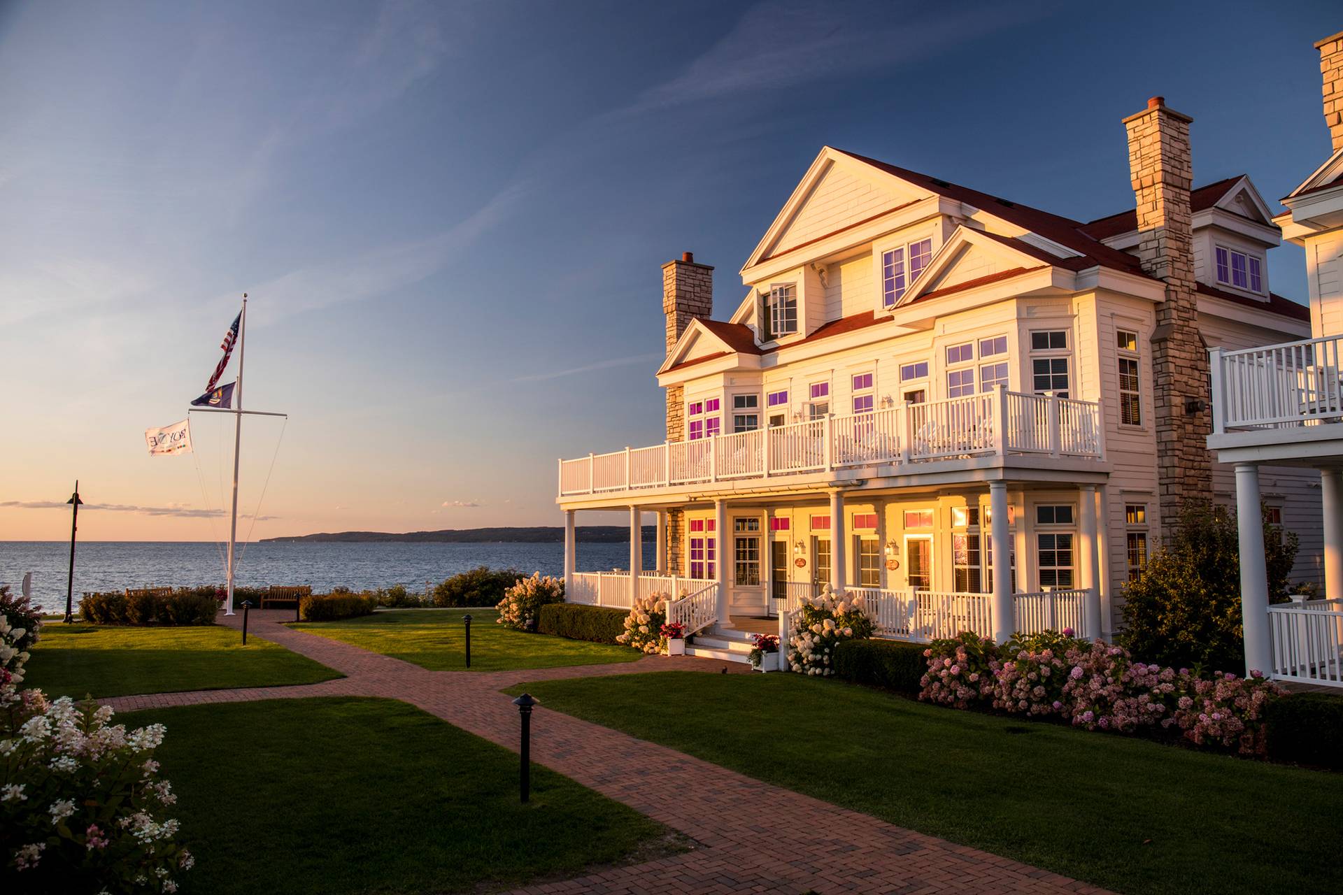 A Cottage summer exterior with rose bushes and Lake Michigan in the background