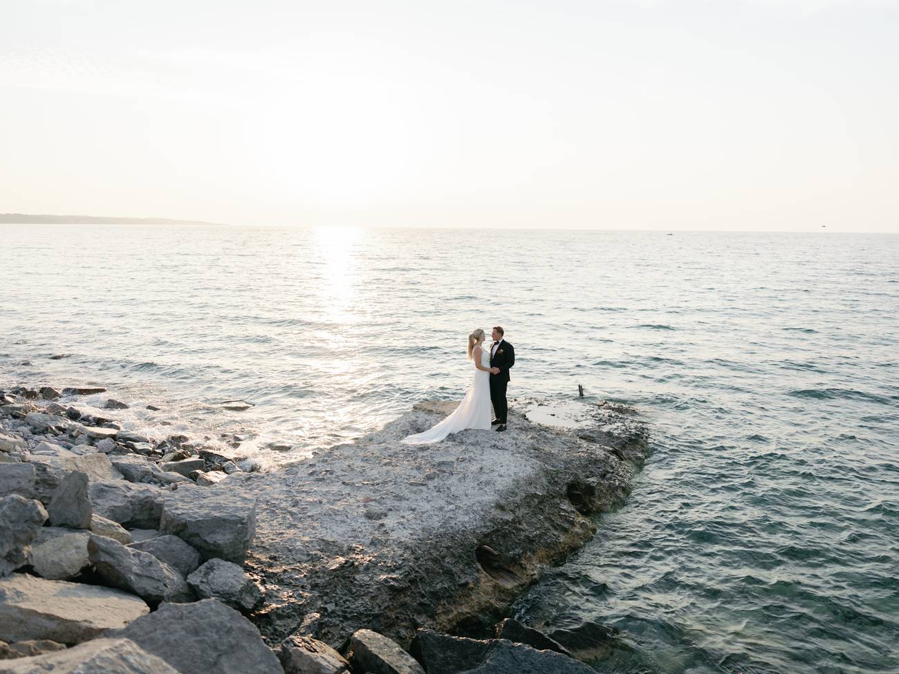 Couple embraces on rocky sunset shore