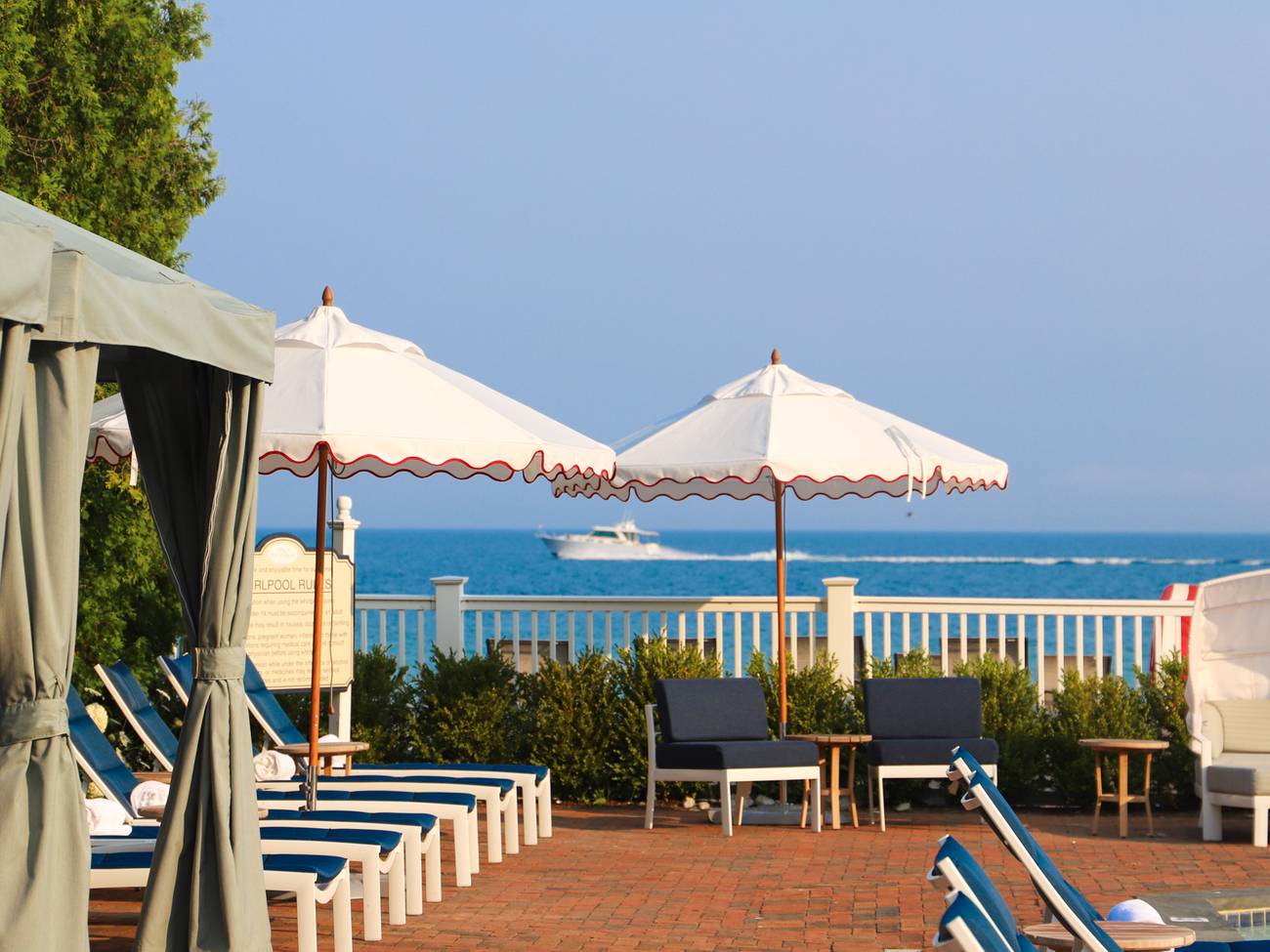Boat drives by on Lake Michigan with pool furniture foreground