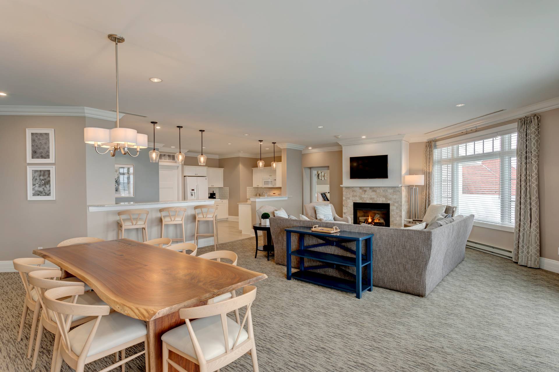 Live edge dining table, sectional couch in front of fireplace, open to breakfast bar, Inn at Bay Harbor penthouse