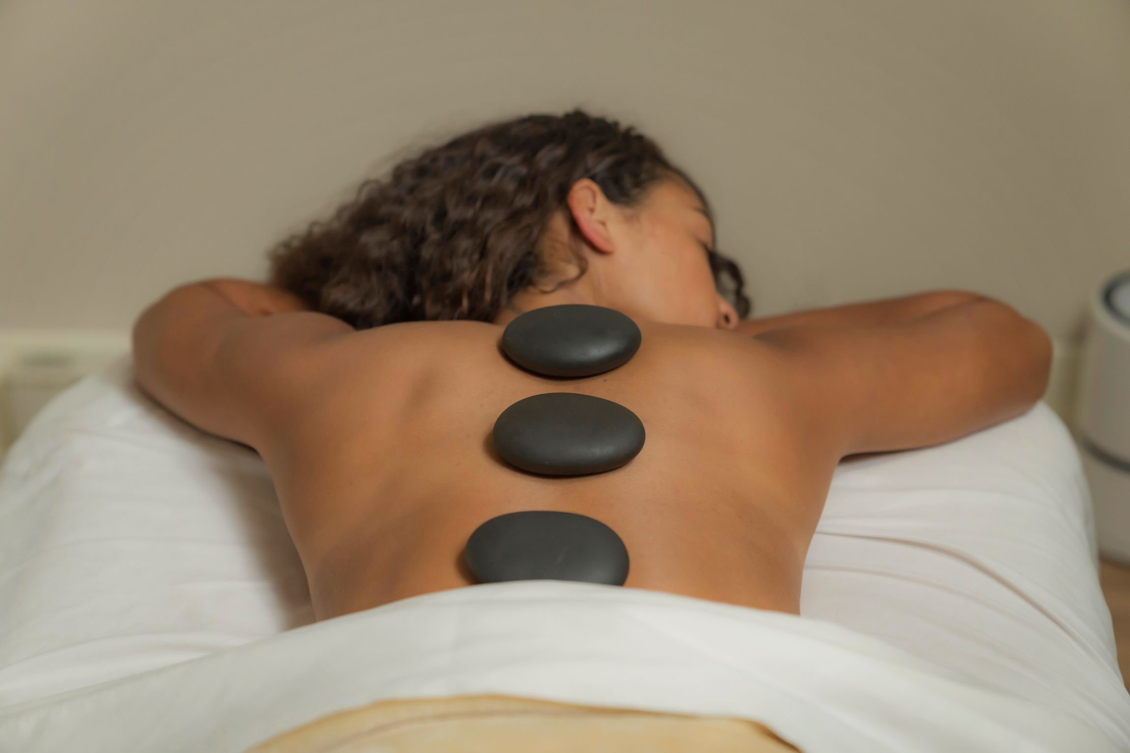 Woman with hot stones for massage, The Spa at Inn at Bay Harbor