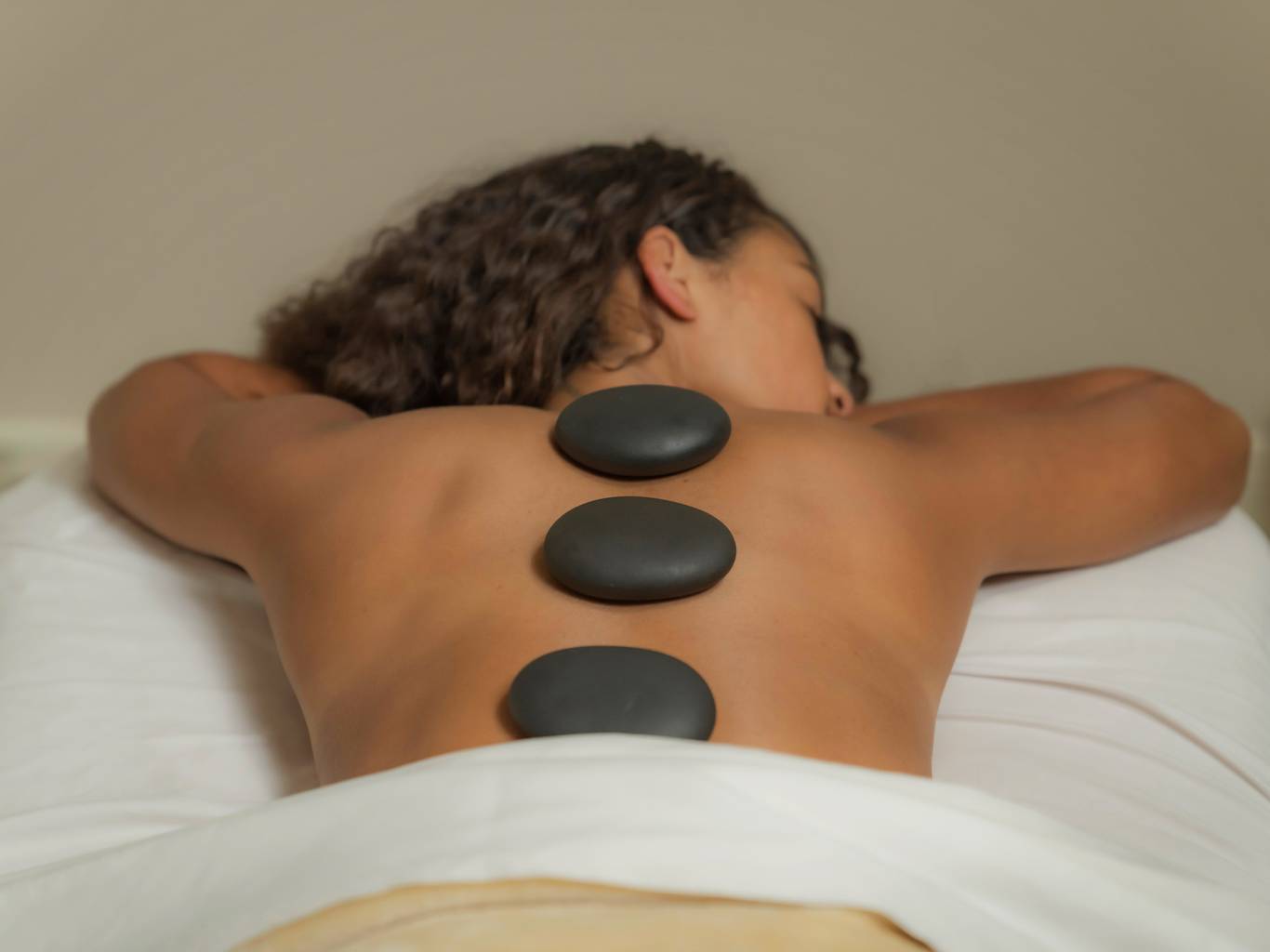 Woman with hot stones for massage, The Spa at Inn at Bay Harbor