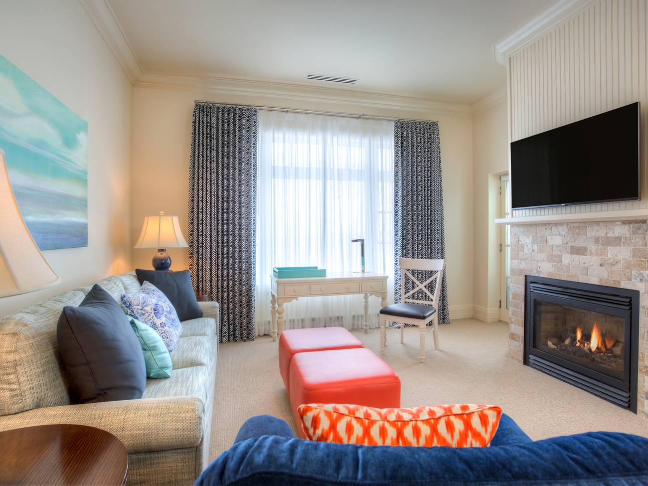 Colorful living area with blue and coral accents, travertine fireplace, Master Suite of Inn at Bay Harbor