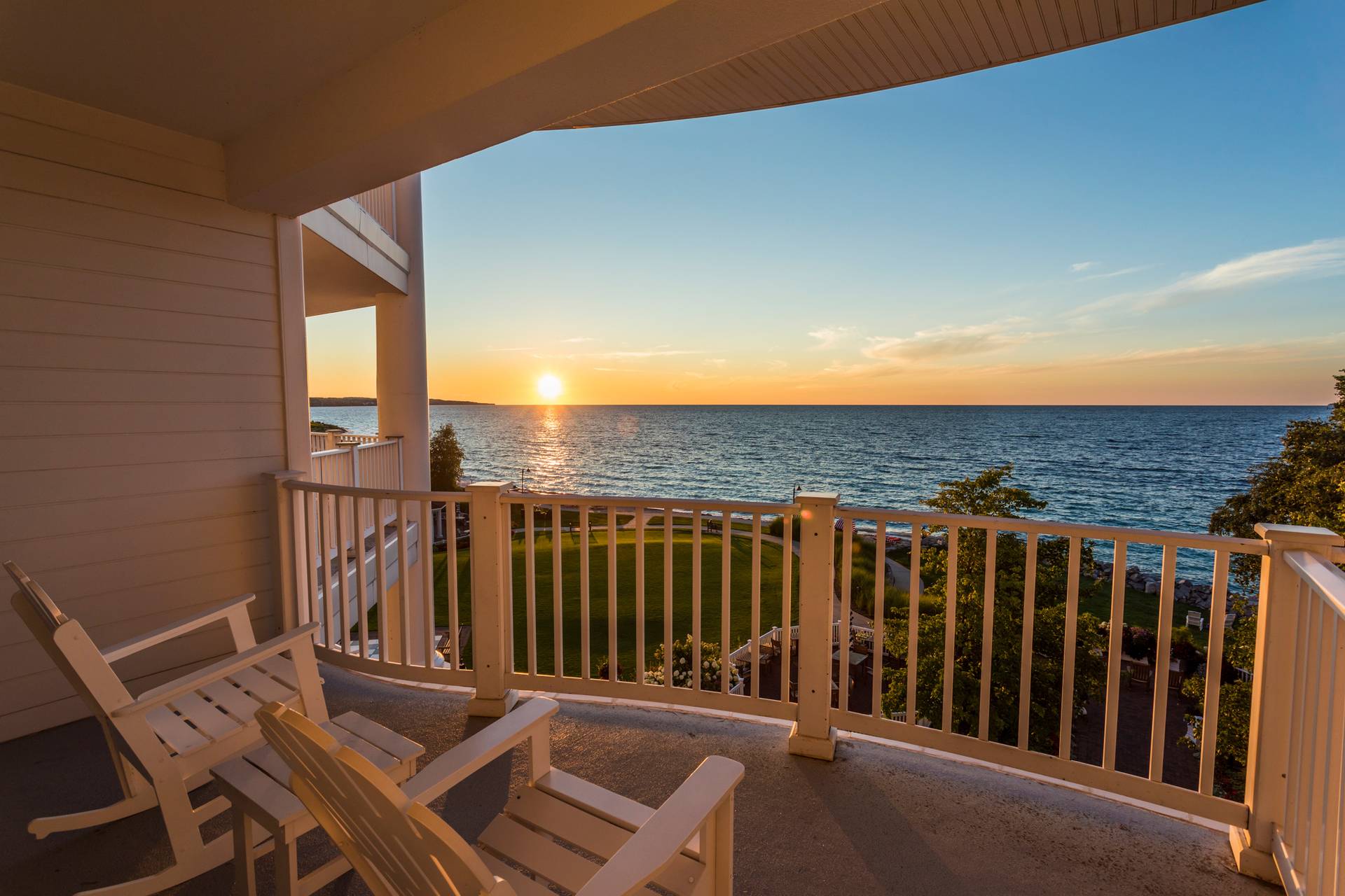 Two white chairs on balcony overlooking sunset along Lake Michigan, Inn at Bay Harbor