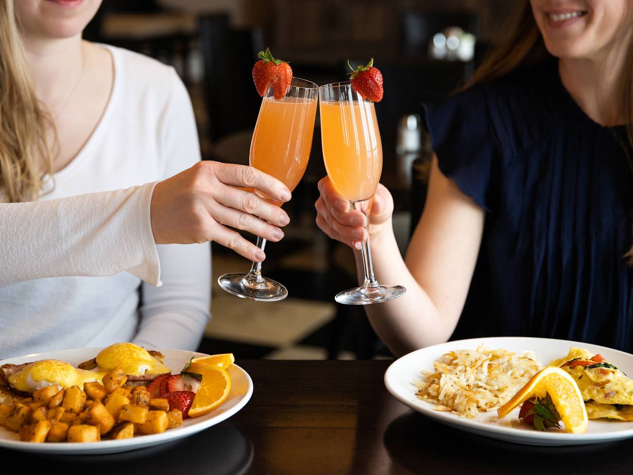Toasting mimosas over breakfast plates